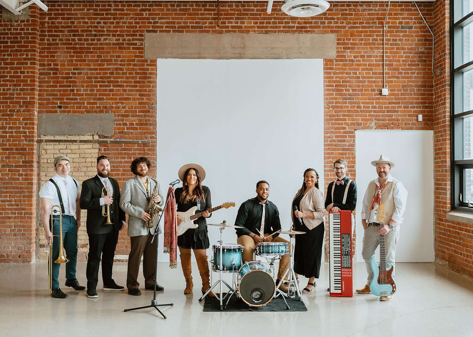 Supersonic Hearts Band members playing instruments and singing on stage during a wedding celebration.