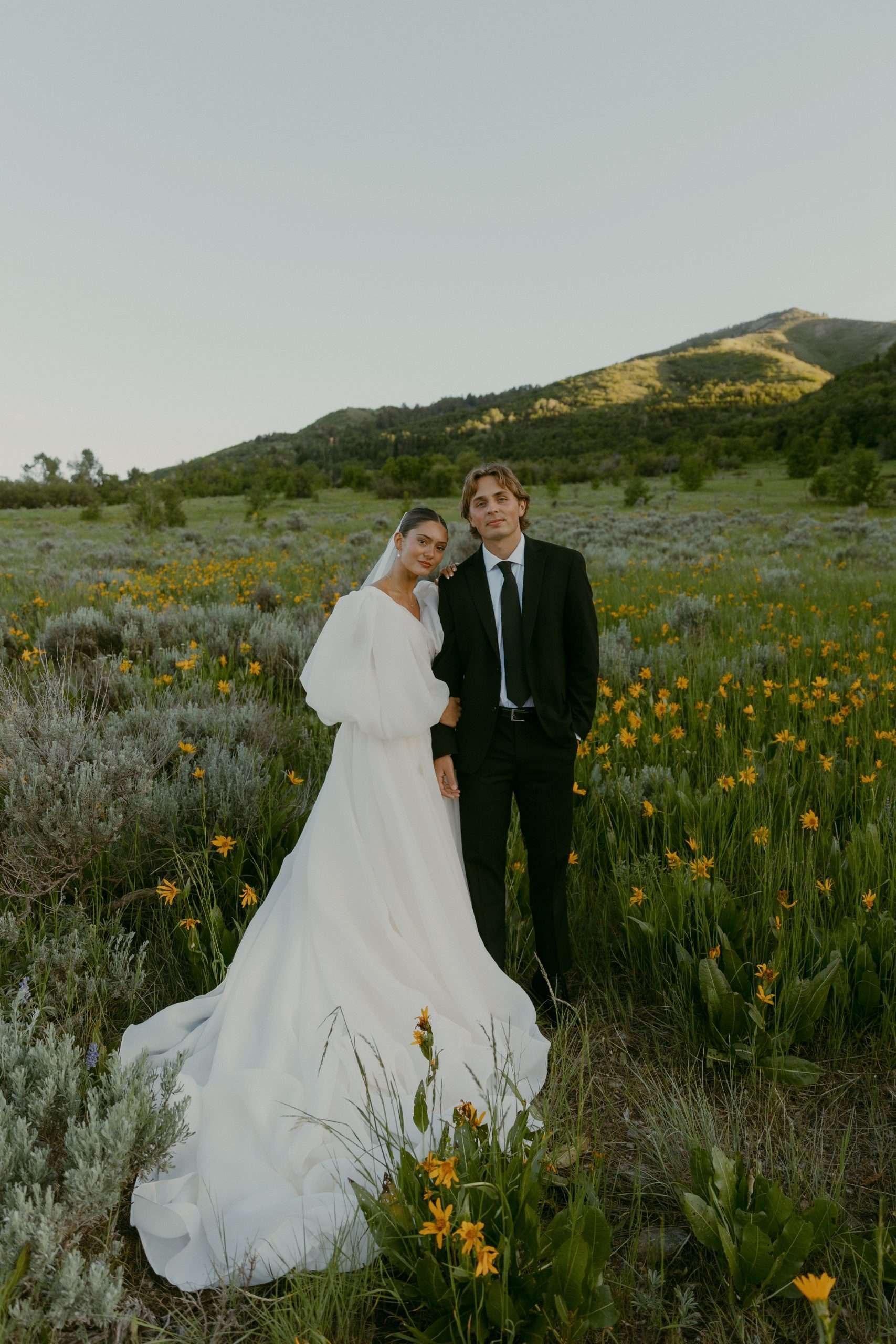 bride and groom standing in a field with yellow flowers utah wedding bridal photos