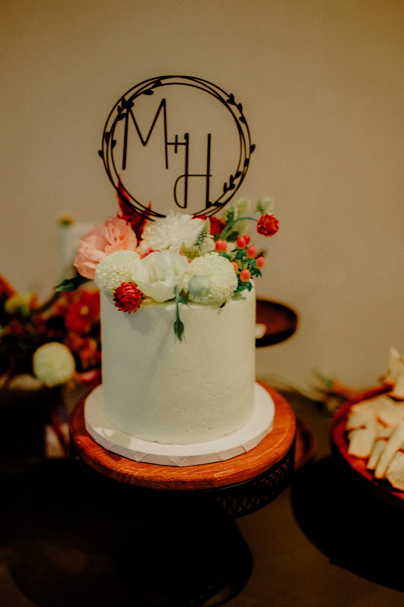 montana summer wedding cake with flowers on top and a chocolate cake monogram