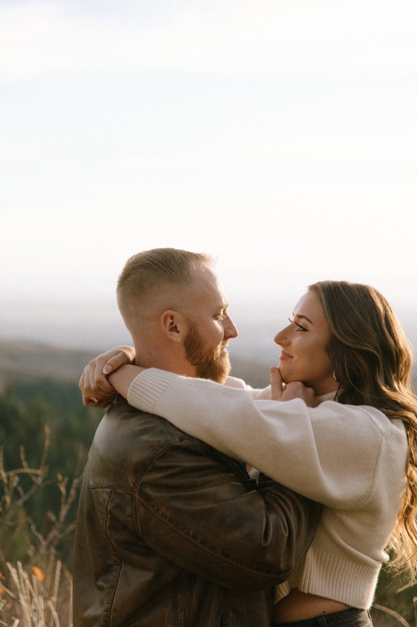 her hands wrapped around his neck and he's holding her face for their Boise Idaho Winter Engagement Session