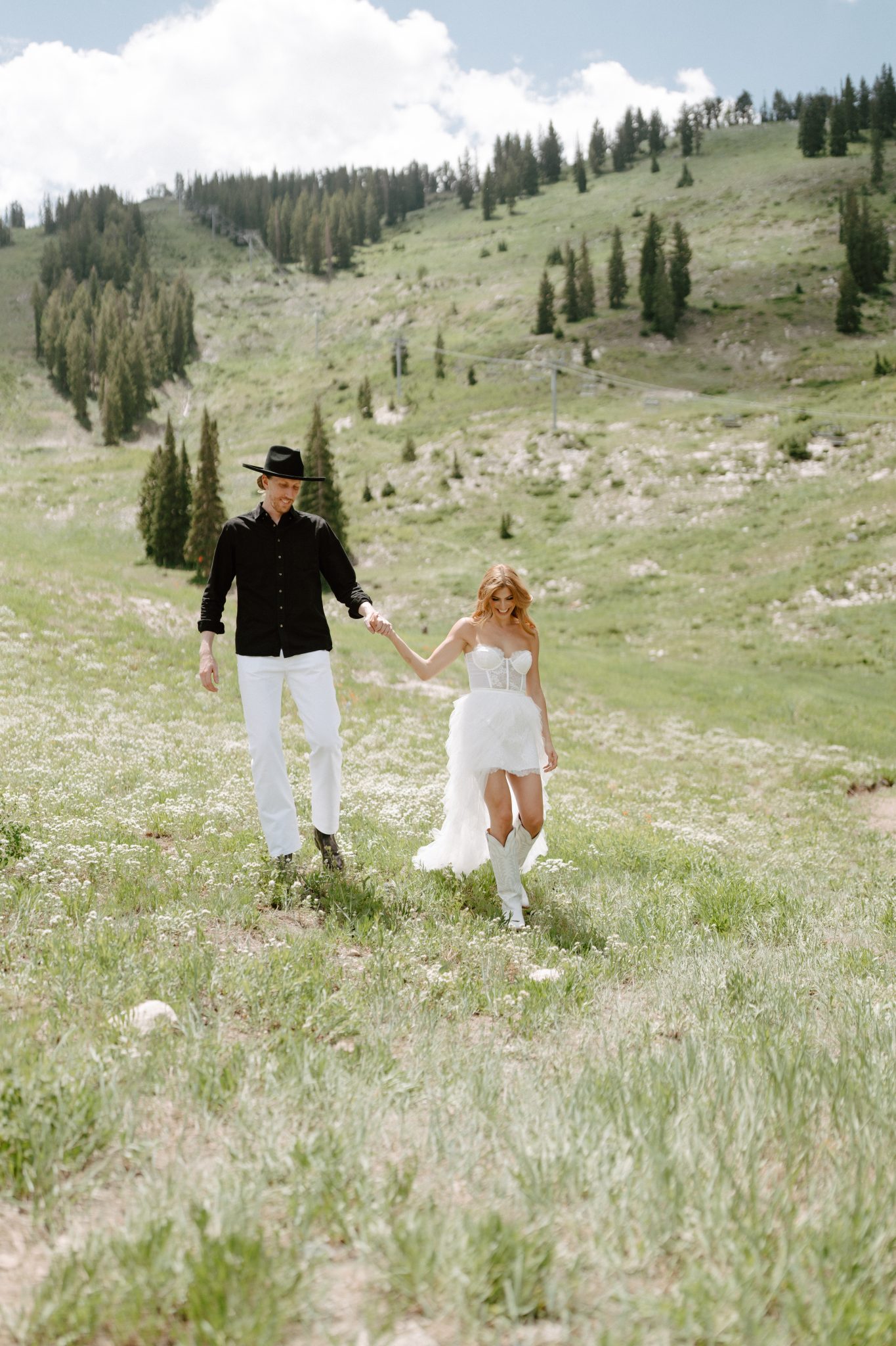 couple walking in the field with their cute matching outfits for their Mountain Utah Engagement Session