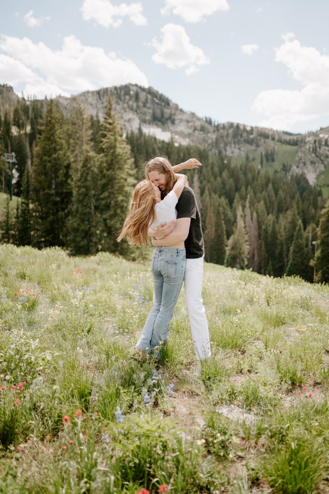 Mountain Utah Engagement Session's couple hugging in the meadows with a tree backdrop