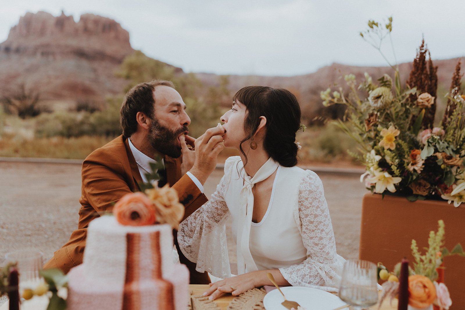 Couple feeding each other cake for a Red Earth Venue Wedding Inspiration