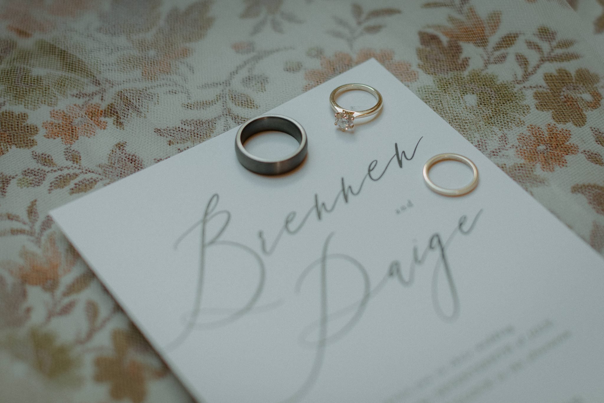White and Green British Columbia Summer Wedding's stationery with the groom's ring and the brides ring set