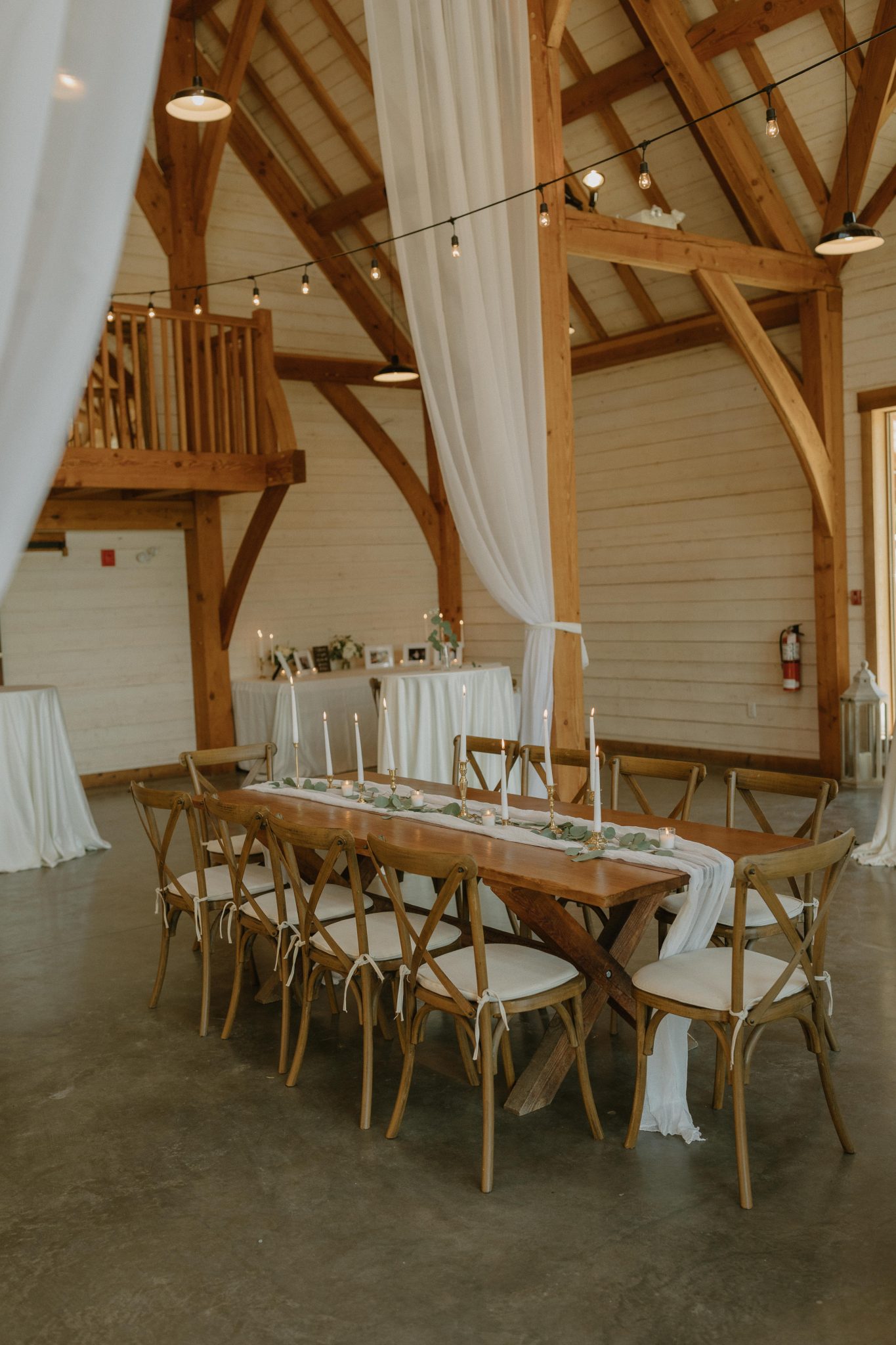 rustic tables and chairs with greenery and white runner down the middle of the table for a White and Green British Columbia Summer Wedding