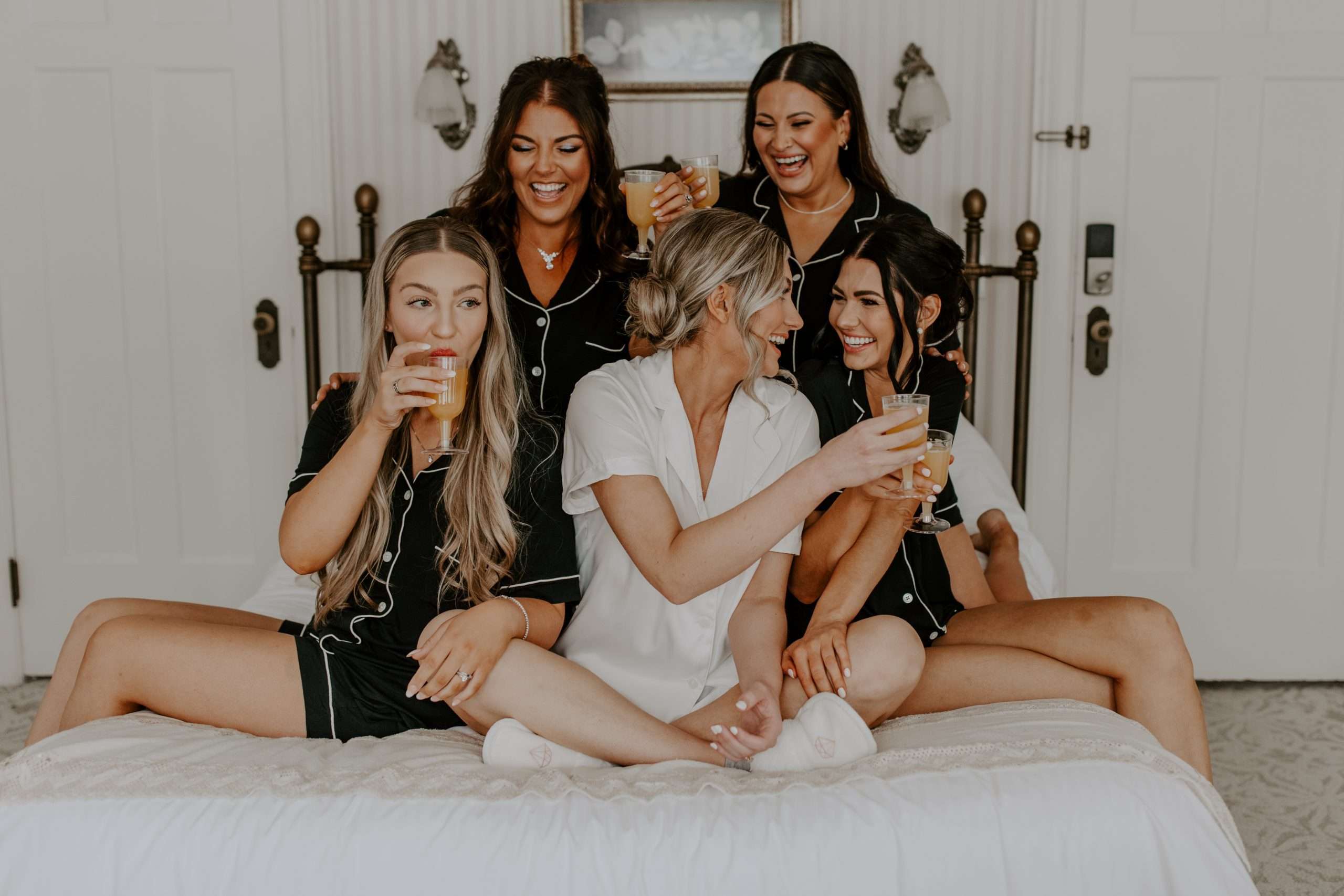bridesmaids and bride enjoying a drink while getting ready for an alberta wedding