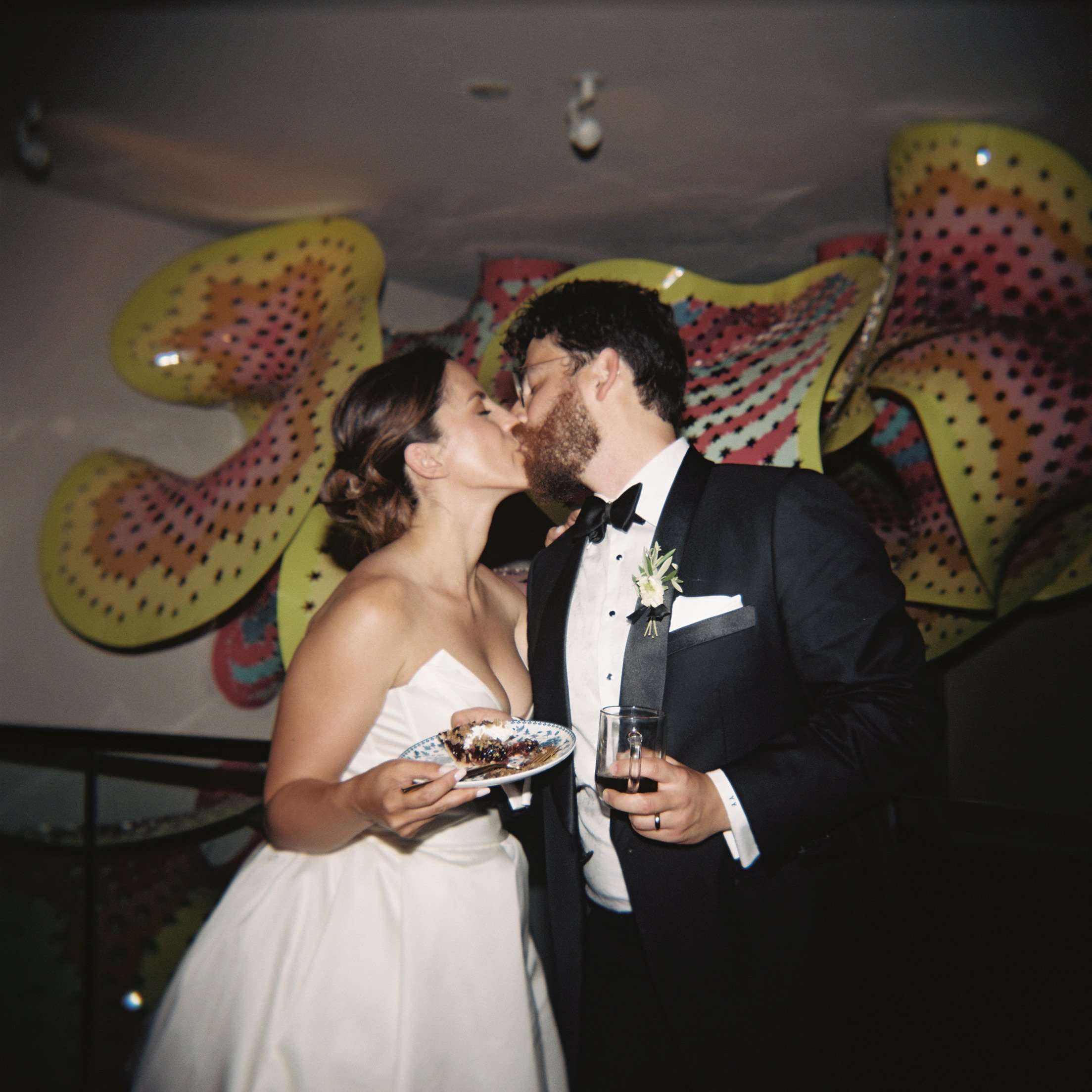 denver garden wedding couple kiss after cutting their cake
