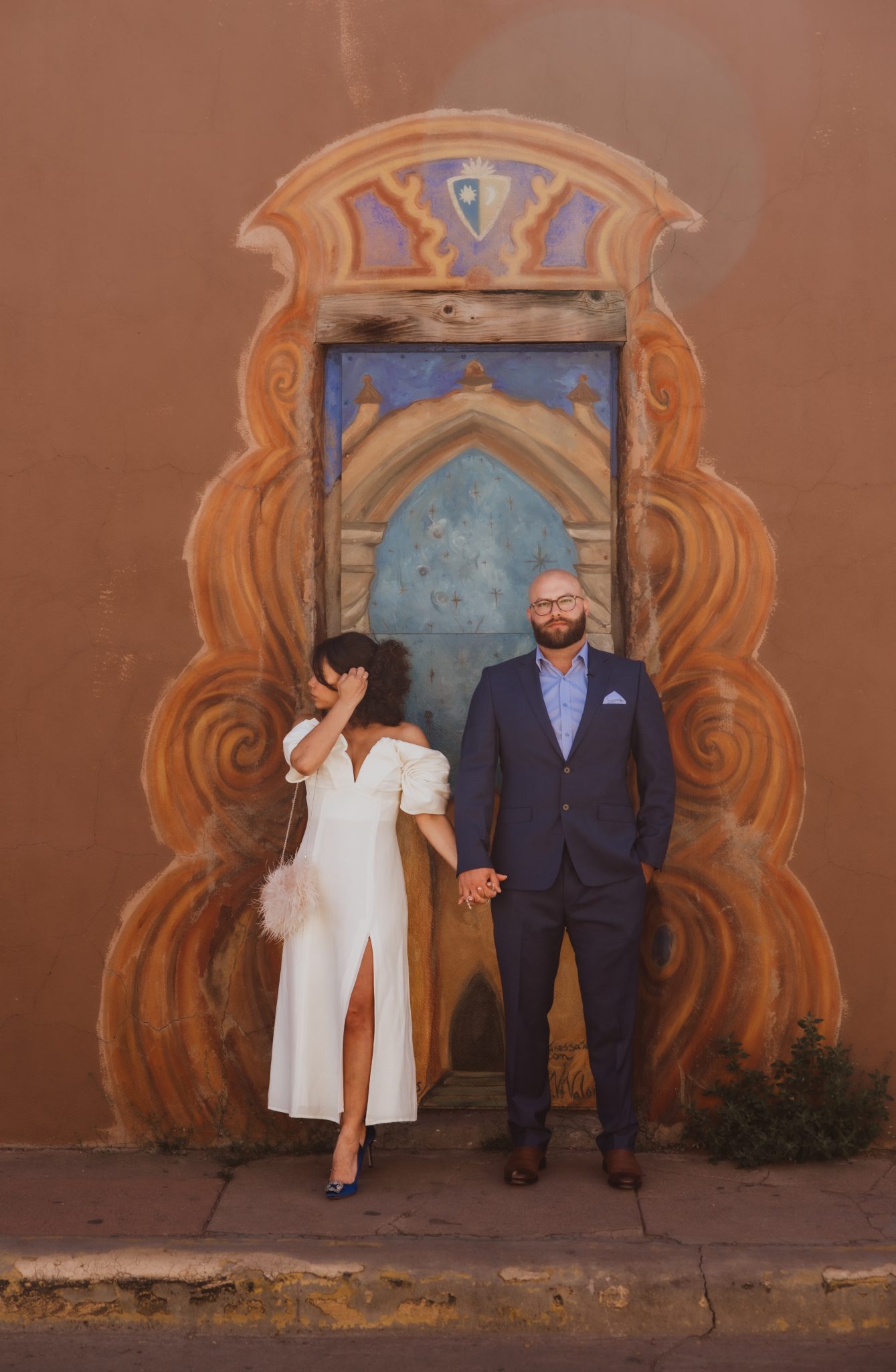 couple standing in front of new mexico art for their intimate new mexico elopement