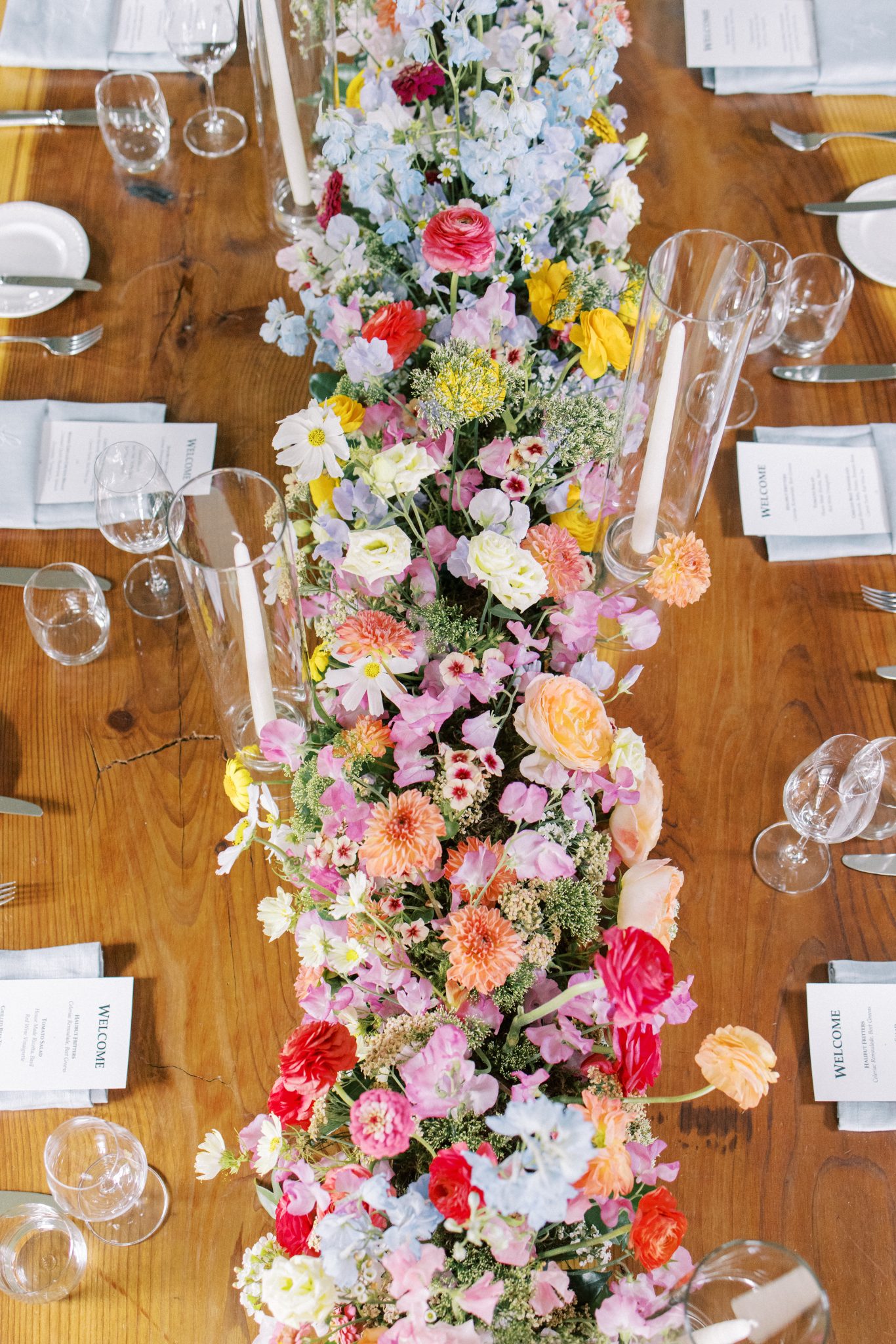 Alberta Summer Wedding's reception floral centerpiece with tapered candles and a pocket fold napkin