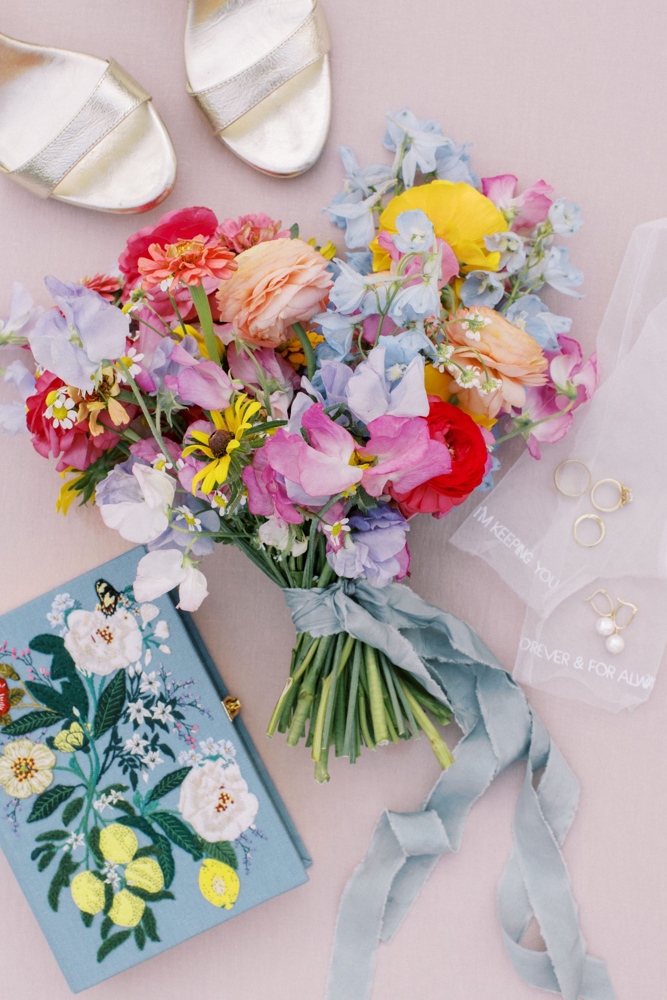 Alberta Summer Wedding details of vibrant and colorful bridal bouquet, bride's shoes, her jewelry, and vow book