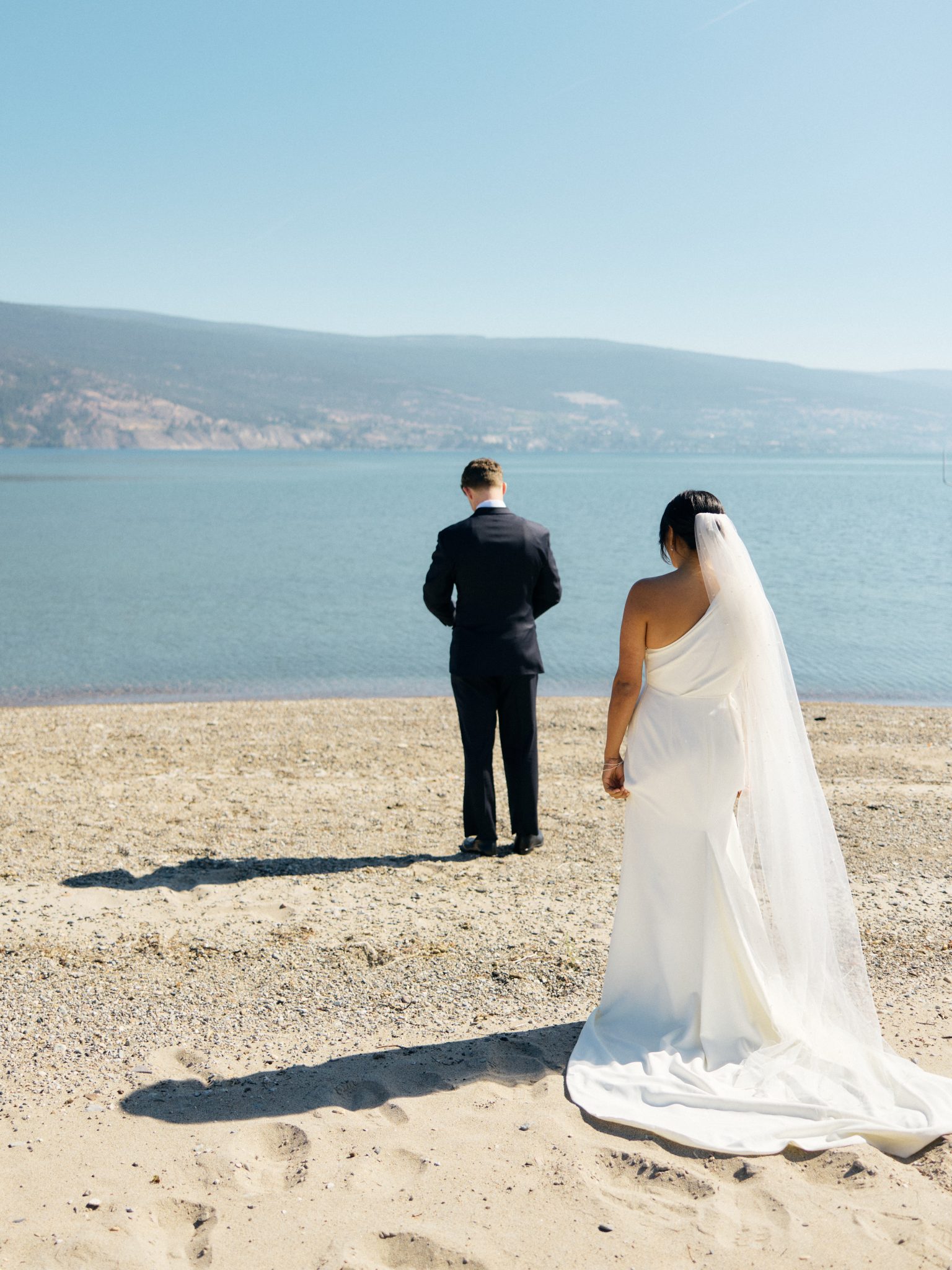 Bride and groom first look with lake and mountain views for their British Columbia Summer Wedding