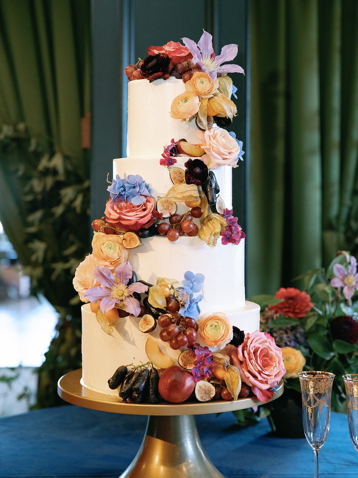 four tiered wedding cake decorated with florals and fruits to add a trendy touch for a Broadmoor Fall Wedding