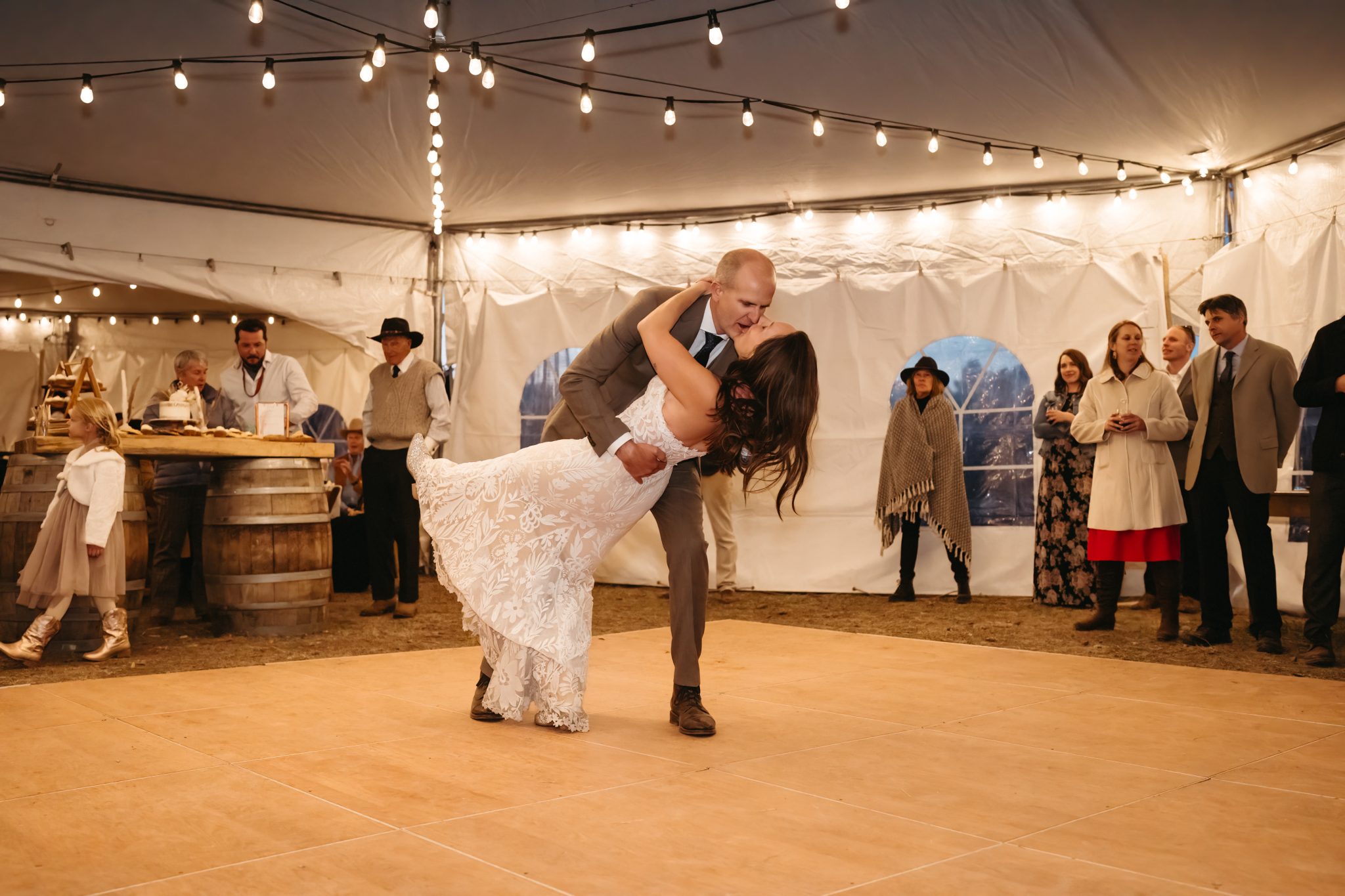 Colorado Fall Wedding couple dance under the market lights as the groom dips the bride and gives her a kiss