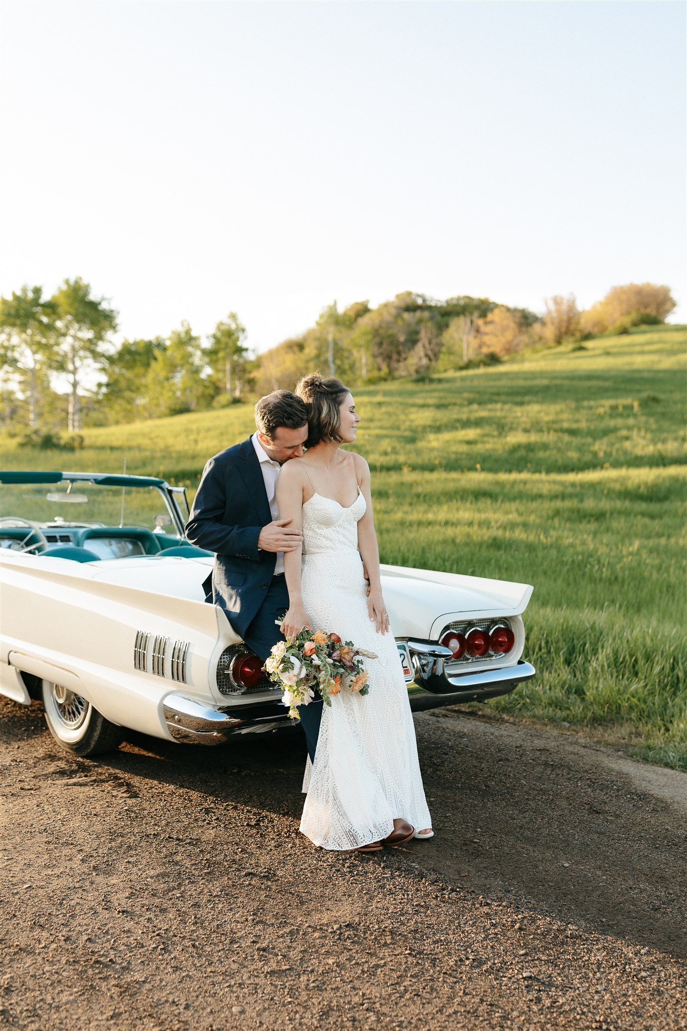 Flying Diamond Ranch Summer Wedding couple with a stunning background and a white Ford Thunderbird vehicle