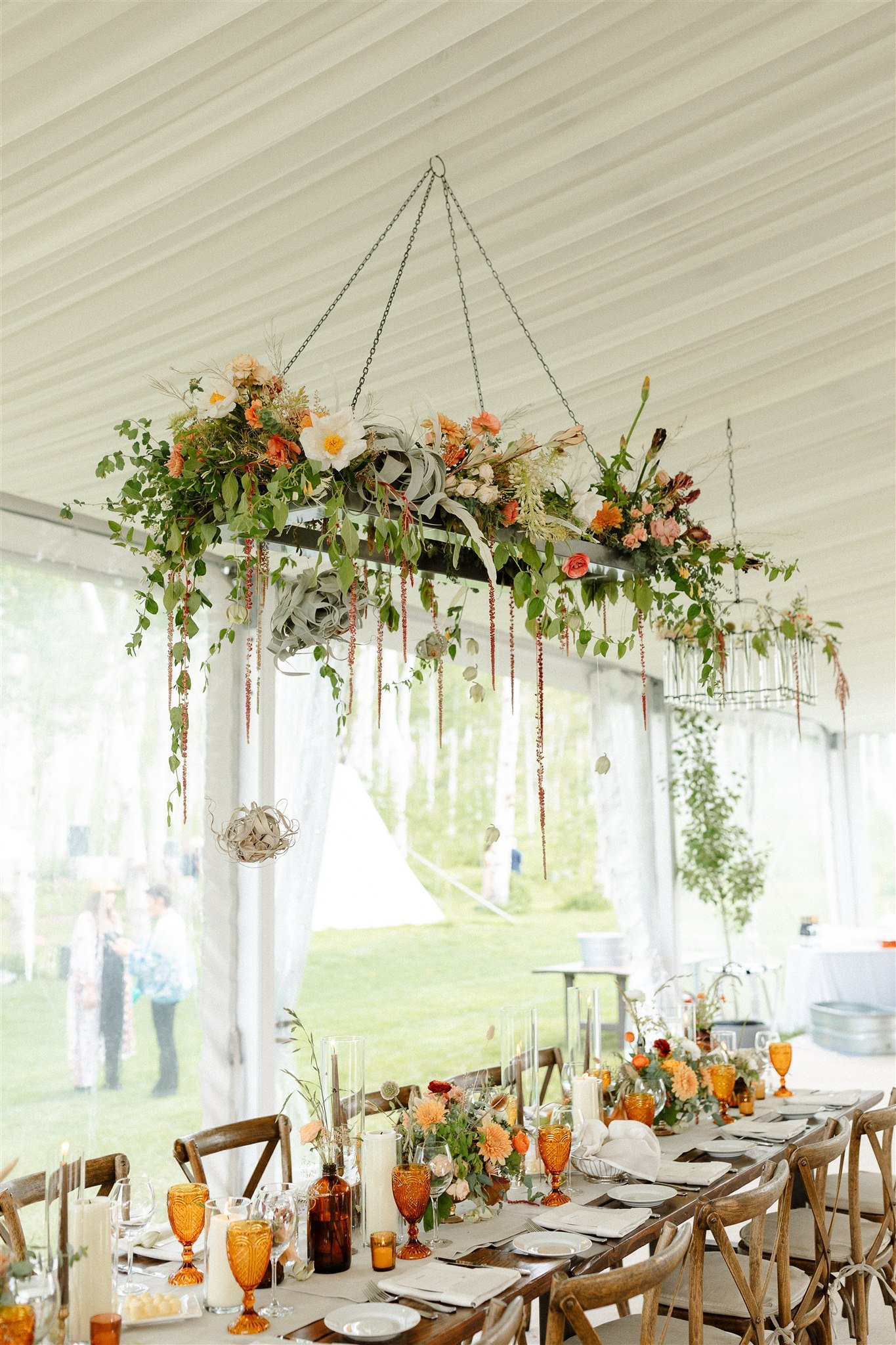 Flying Diamond Ranch Summer Wedding tented reception with a hanging arrangement over the reception wooden table