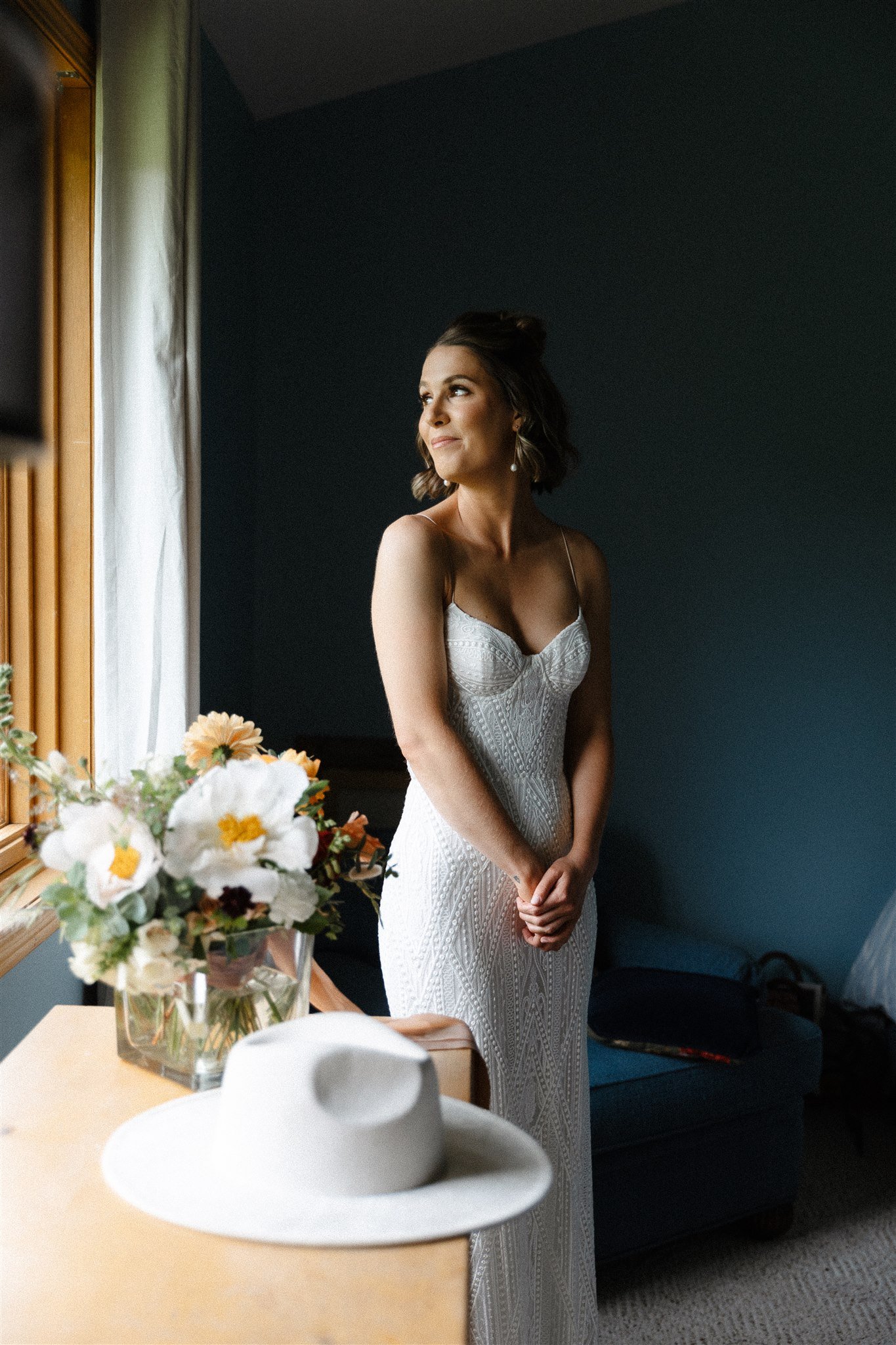 Flying Diamond Ranch Summer Wedding bride in her stunning wedding dress with her bouquet of flowers and white hat as an adorable accessory