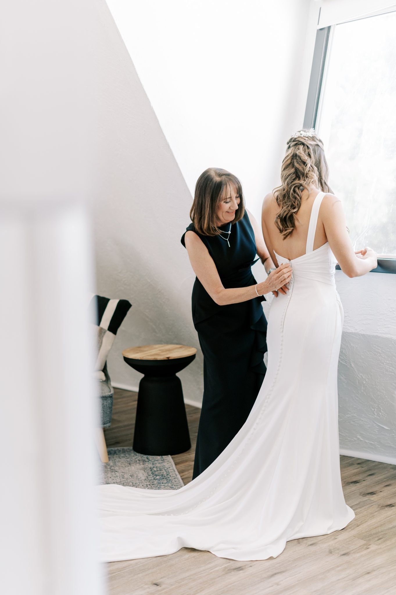 Idaho Summer Wedding bride getting ready as her mom helps the bride zip up her dress