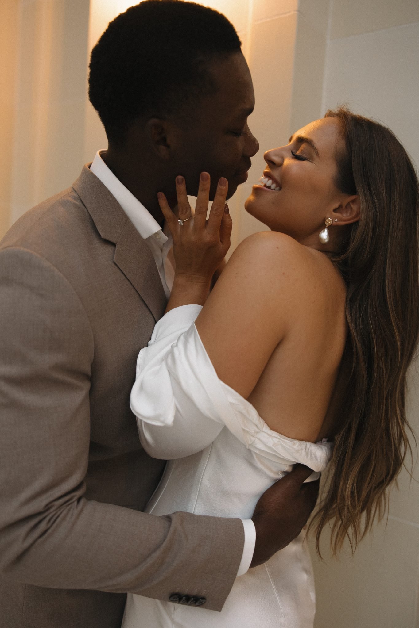 Groom holds bride in his arms as she gently holds his face for Utah wedding bridals