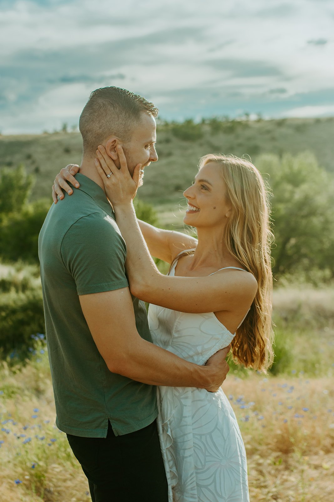 Idaho Summer Engagement Session where his hand is on her lower back and her hands are on his back and face as they gaze into each other's eyes