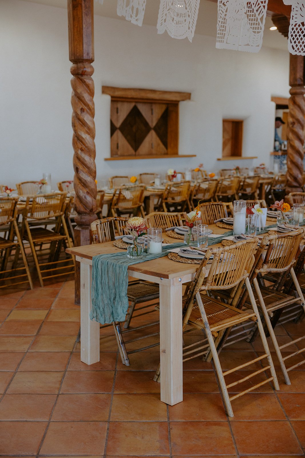 The Stakeout Taos Wedding reception area with decorated dinner tables, a teal runner, and small floral arrangements