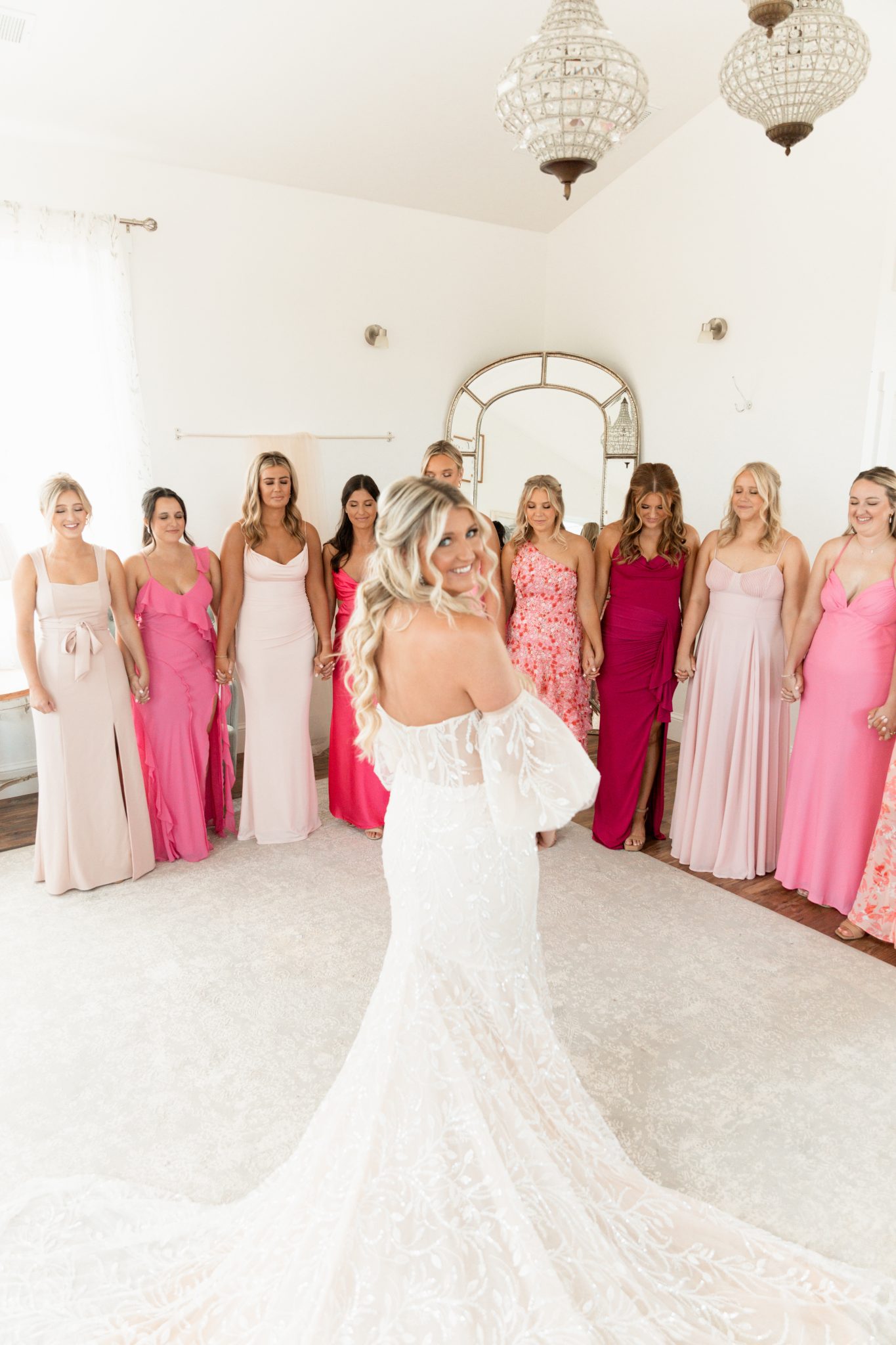 Bonnie Blue's Summer Wedding bride having a first look with her bridesmaids that are dressed in different pink floor length dresses