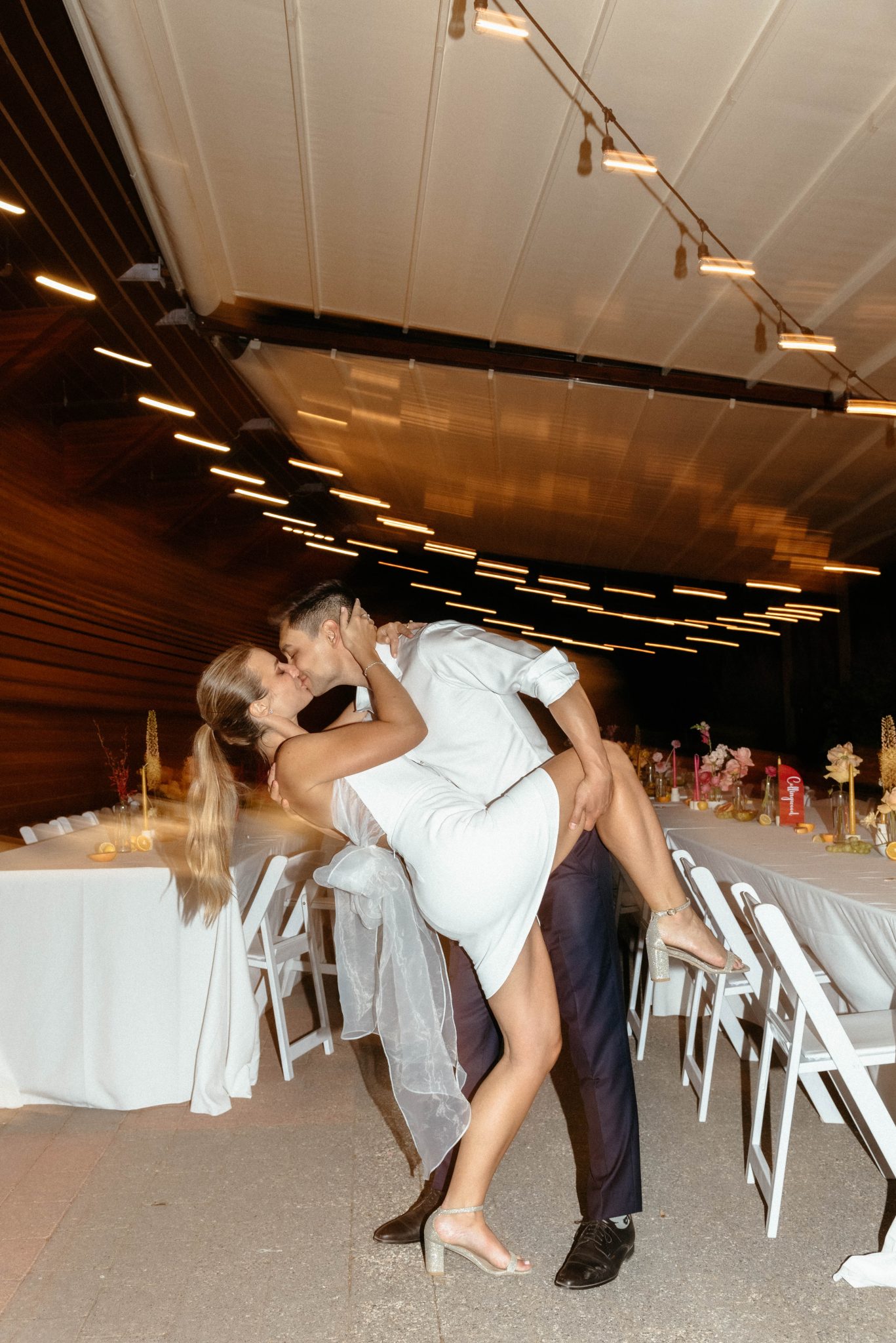 British Columbia Summer Wedding bride in her second dress with the couple in the reception area kissing