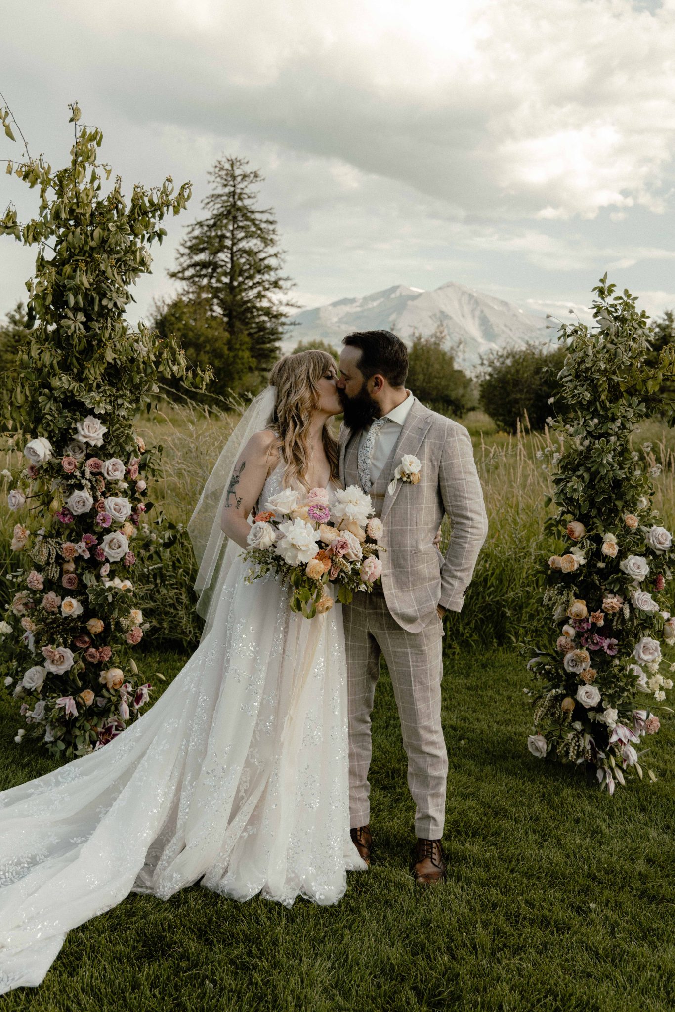 Carbondale Colorado Summer Wedding couple kissing at their ceremony altar with the stunning mountains in the background