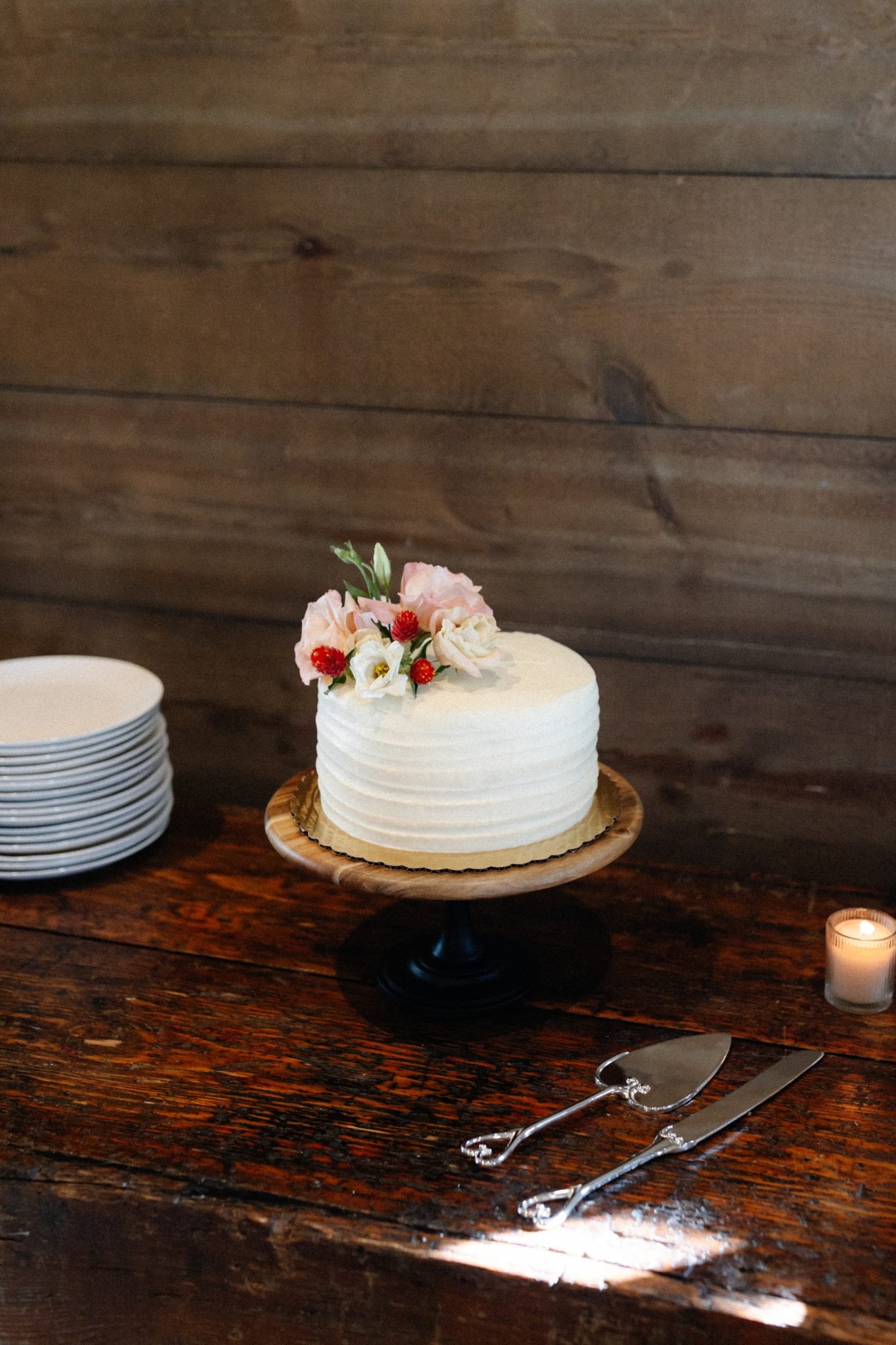 Copper Rose Ranch Wedding textured cutting cake with pink, white, and red florals on top for decoration