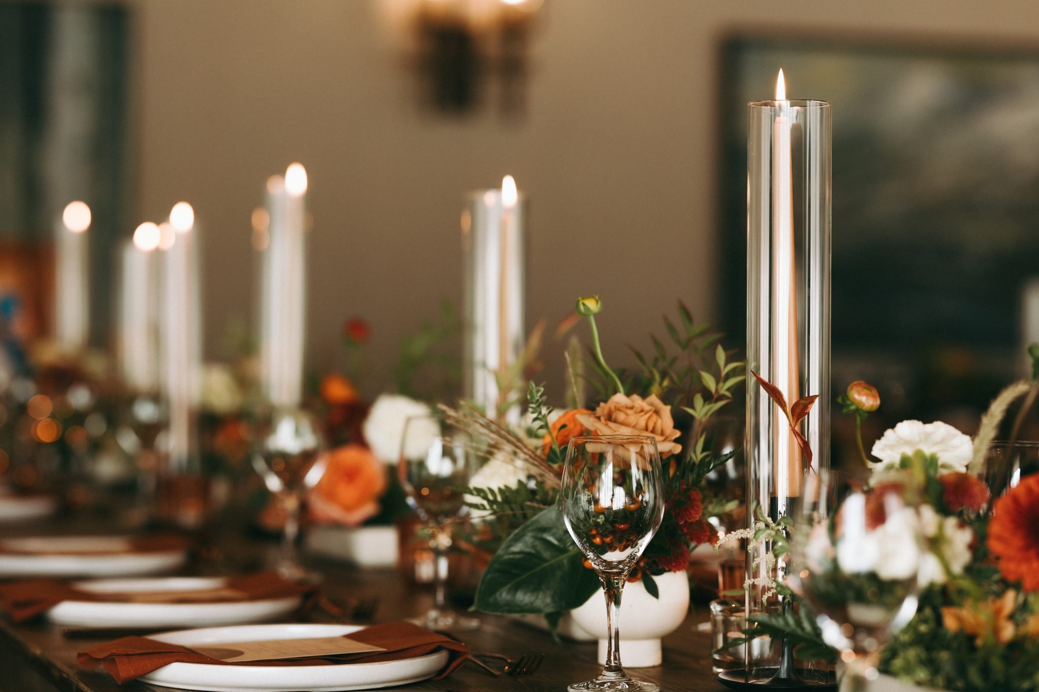 Fairmont Jasper Park Lodge Wedding reception tables of tapered candles and low floral arrangements down the center of the table