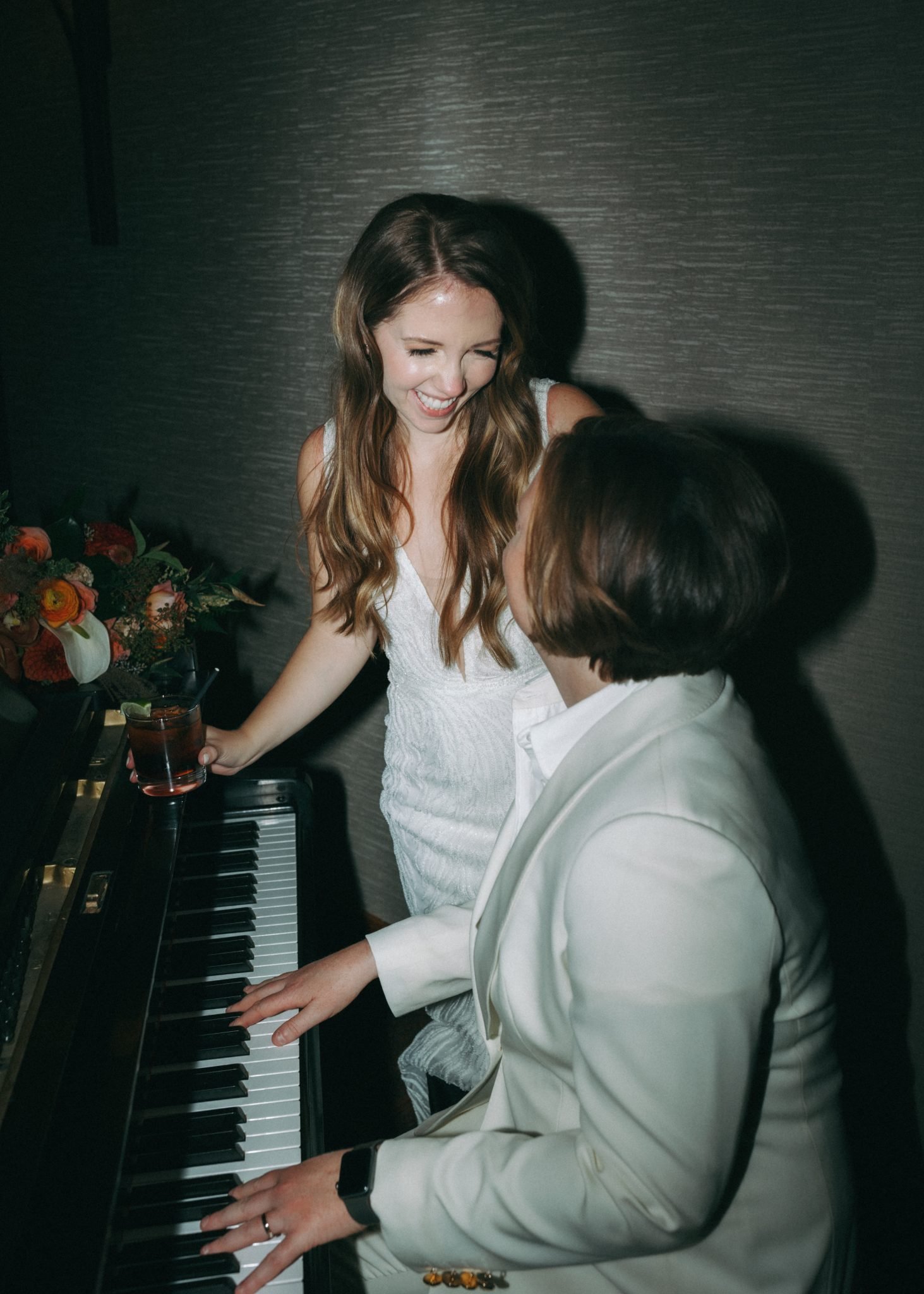 Fairmont Jasper Park Lodge Wedding lbgtqa couple enjoying as one significant other plays the piano for the other