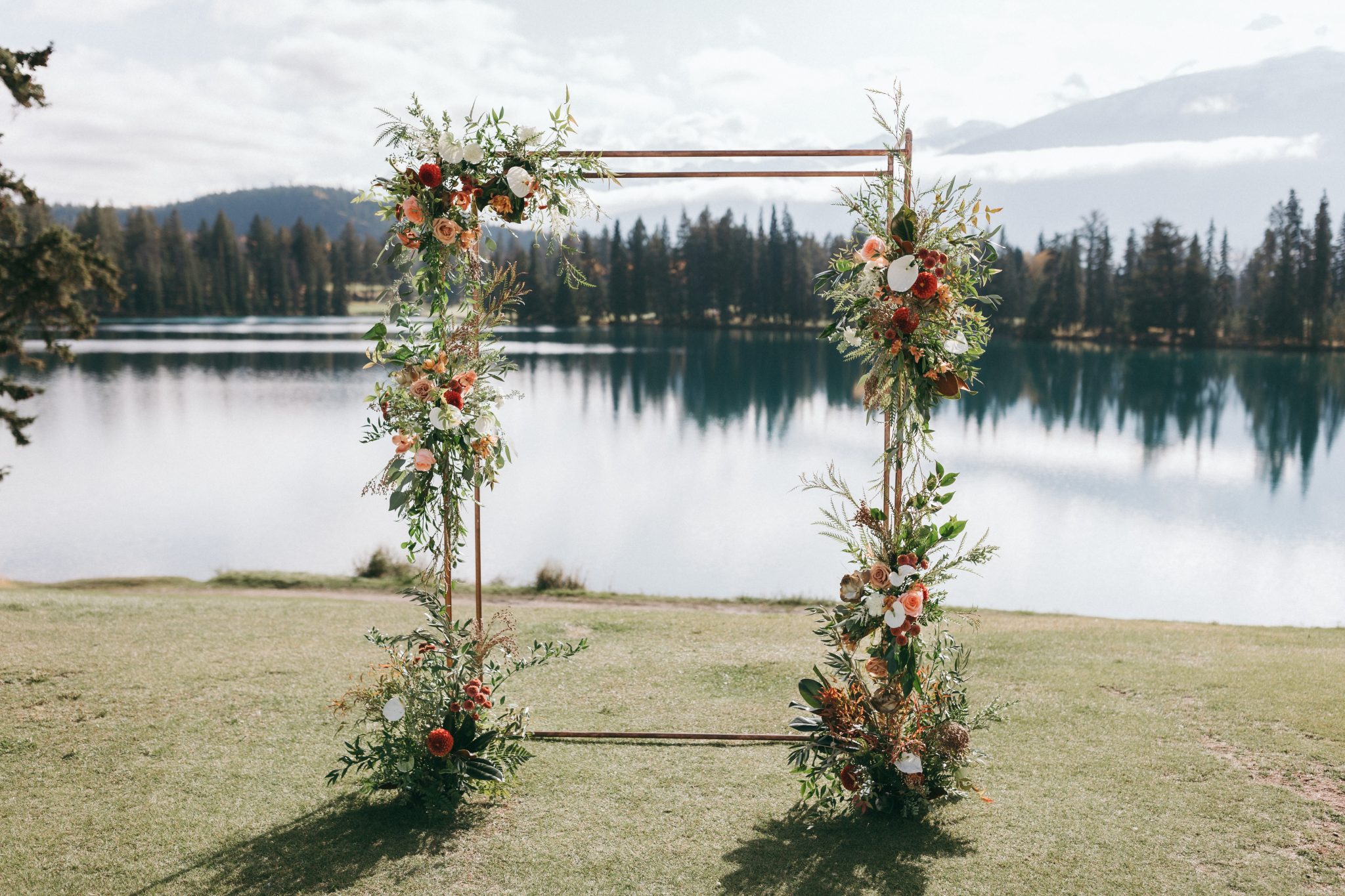 Fairmont Jasper Park Lodge Wedding floral arch with a lake and mountain view