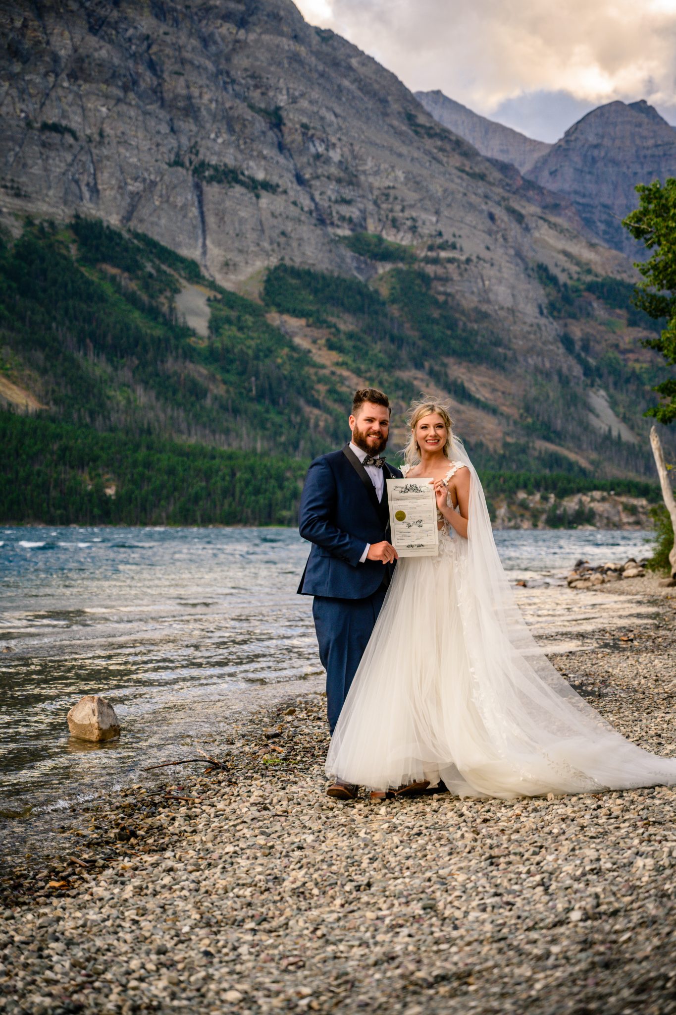 Glacier National Park Elopement couple standing with their signed marriage license with a stunning backdrop