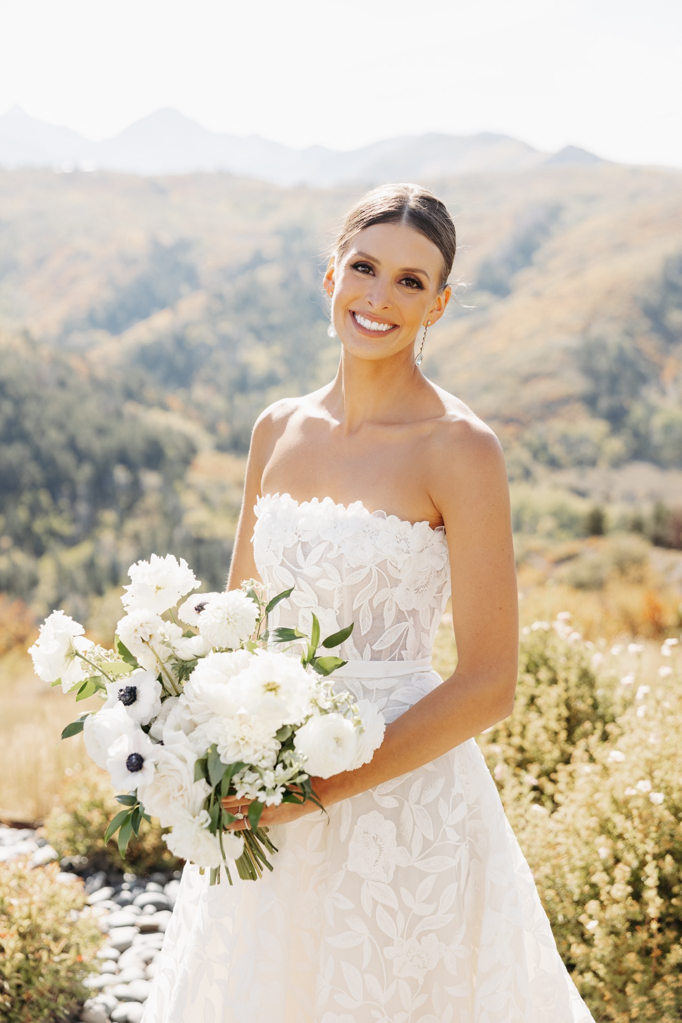 Snowmass Fall Wedding bride wearing a stunning floral strapless wedding dress holding her white bouquet