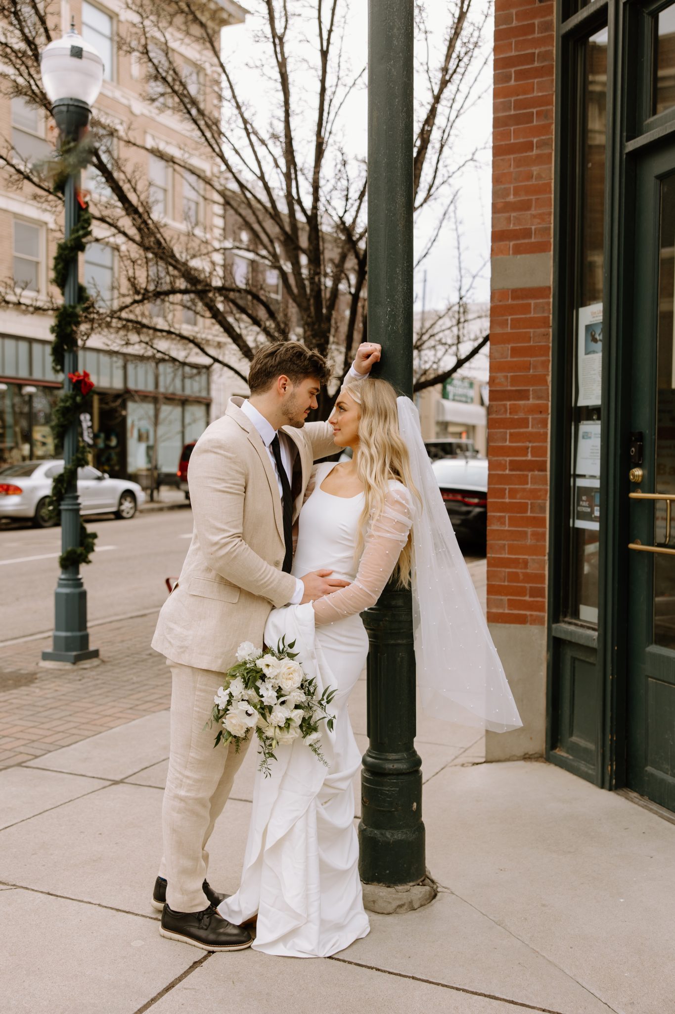 Winter Idaho Bridals at The Paris Studios couple leaning up against a pole as they look deeply into each other's eyes in the streets of Idaho