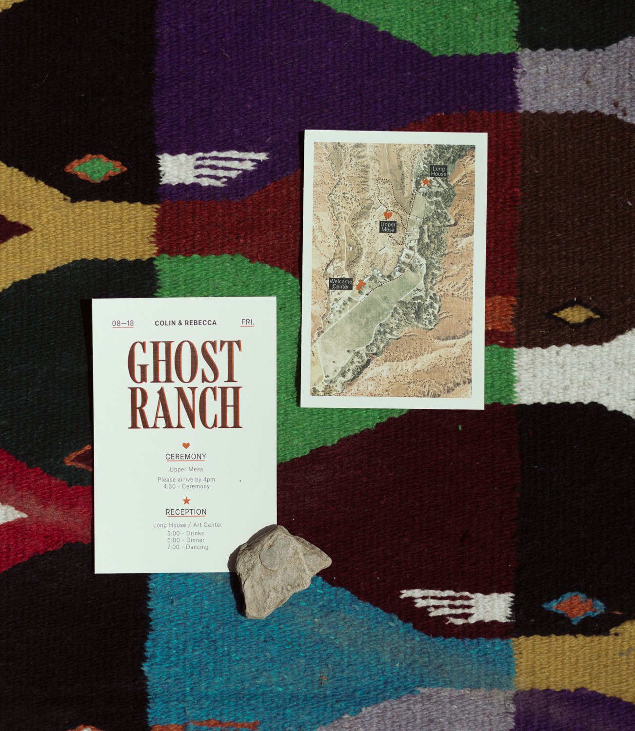Wedding invitation and map for a Ghost Ranch wedding laid out on a vibrant, patterned rug.