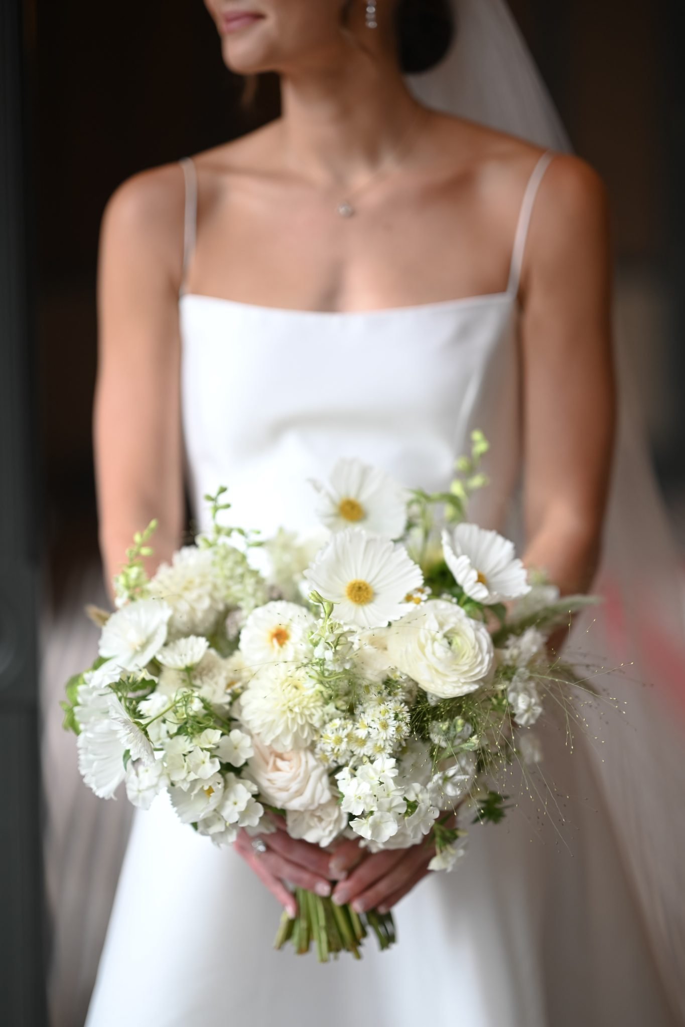 Bride holding a bouquet of white flowers at the Hotel Jerome wedding.