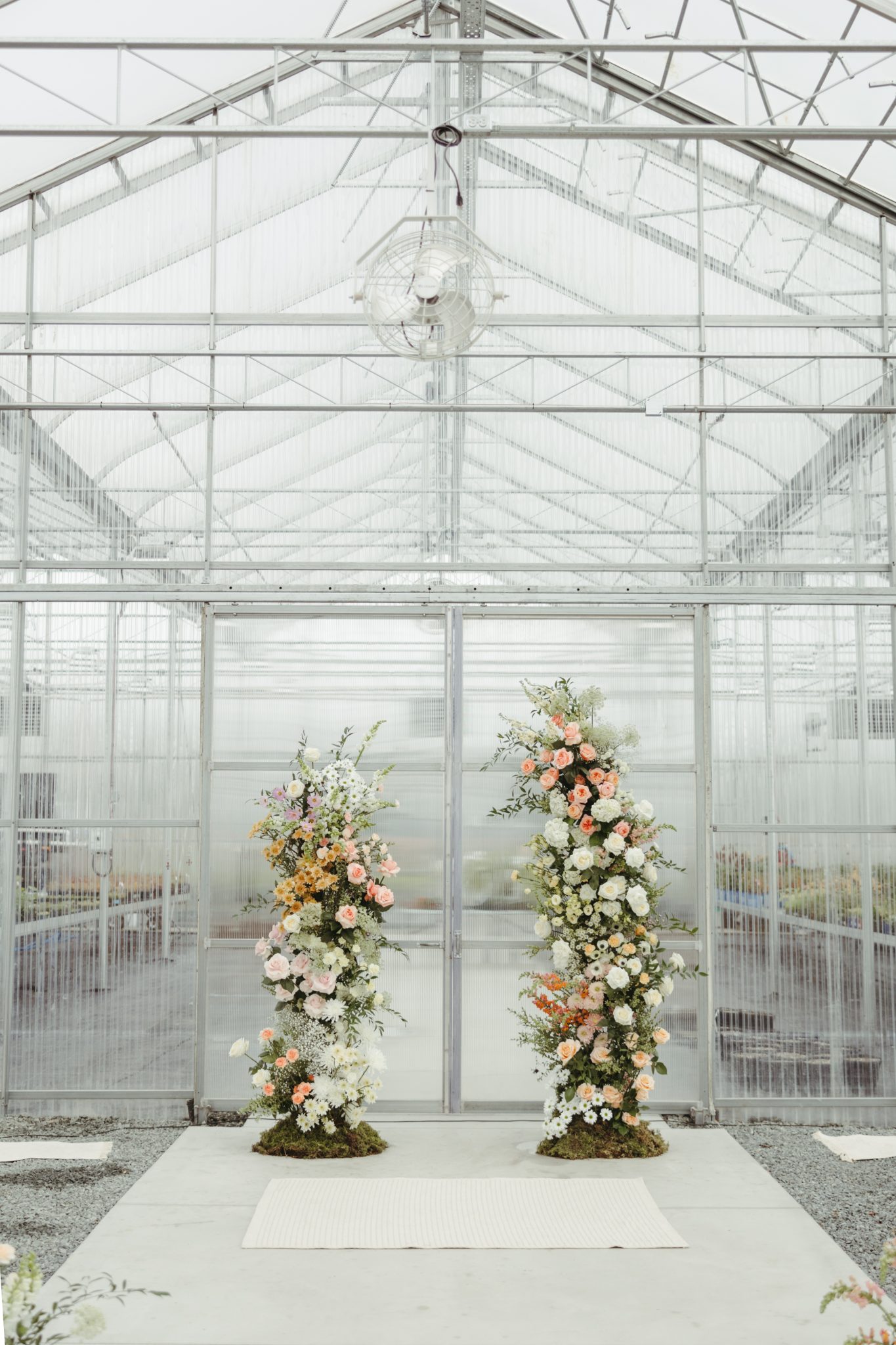 Beautiful floral arrangements at the entrance of a greenhouse venue for a colorful British Columbia wedding.