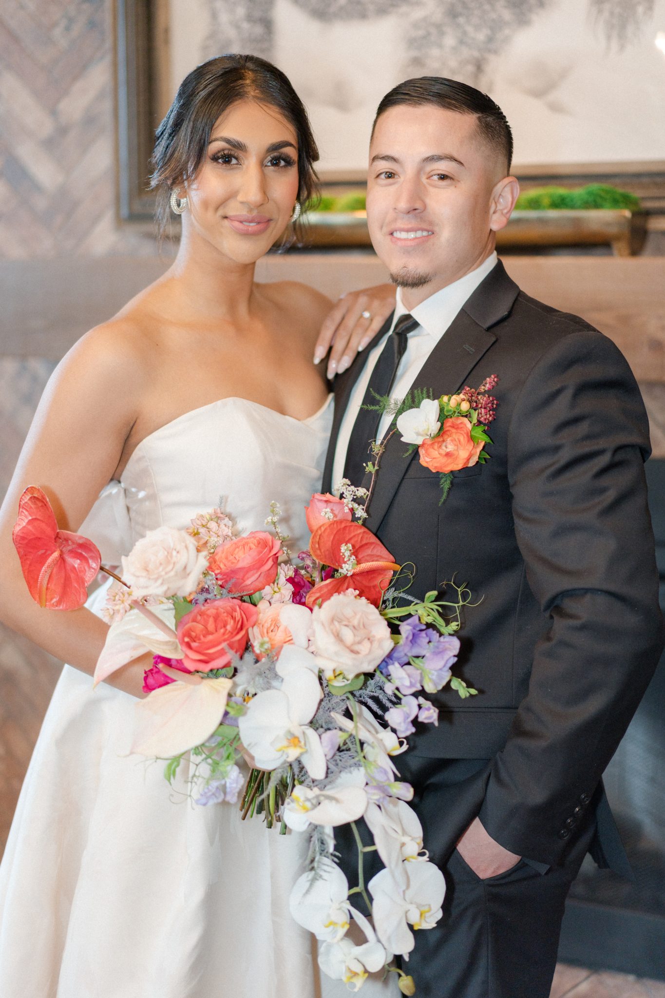Bride and groom posing with a colorful bouquet at their Downtown Colorado wedding.