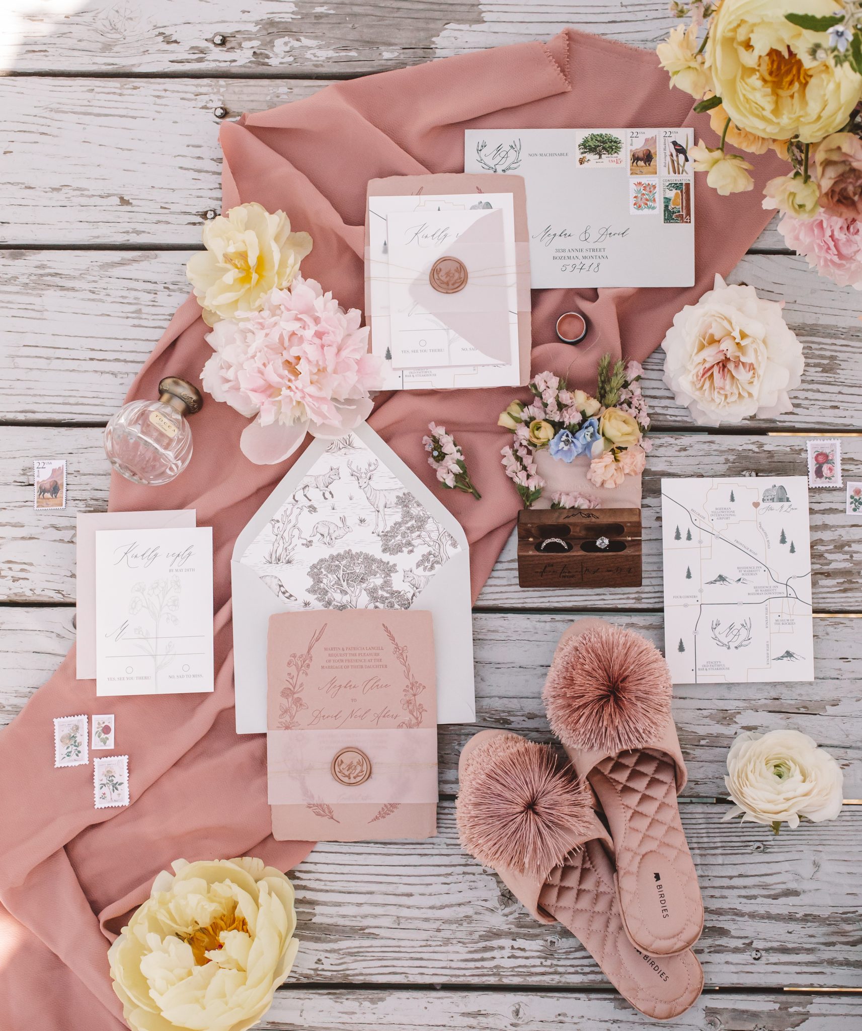 Flat lay of wedding invitations and accessories on pink fabric for a Montana Summer Wedding