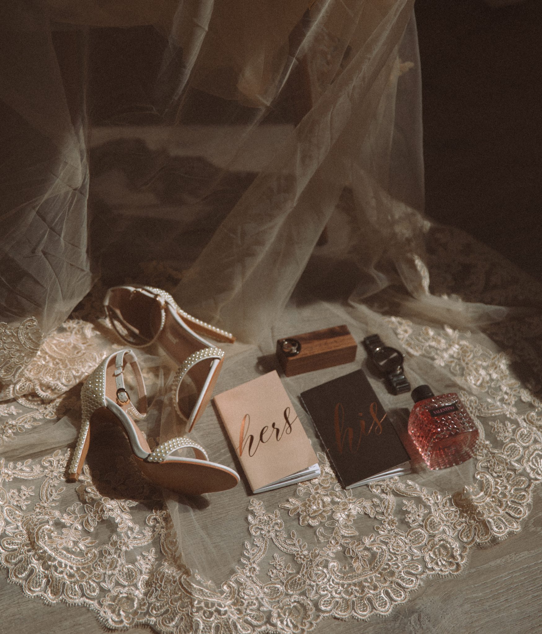 The bride’s accessories and vow books are beautifully arranged on a lace veil, symbolizing the intimate details of a simple Colorado mountain elopement.