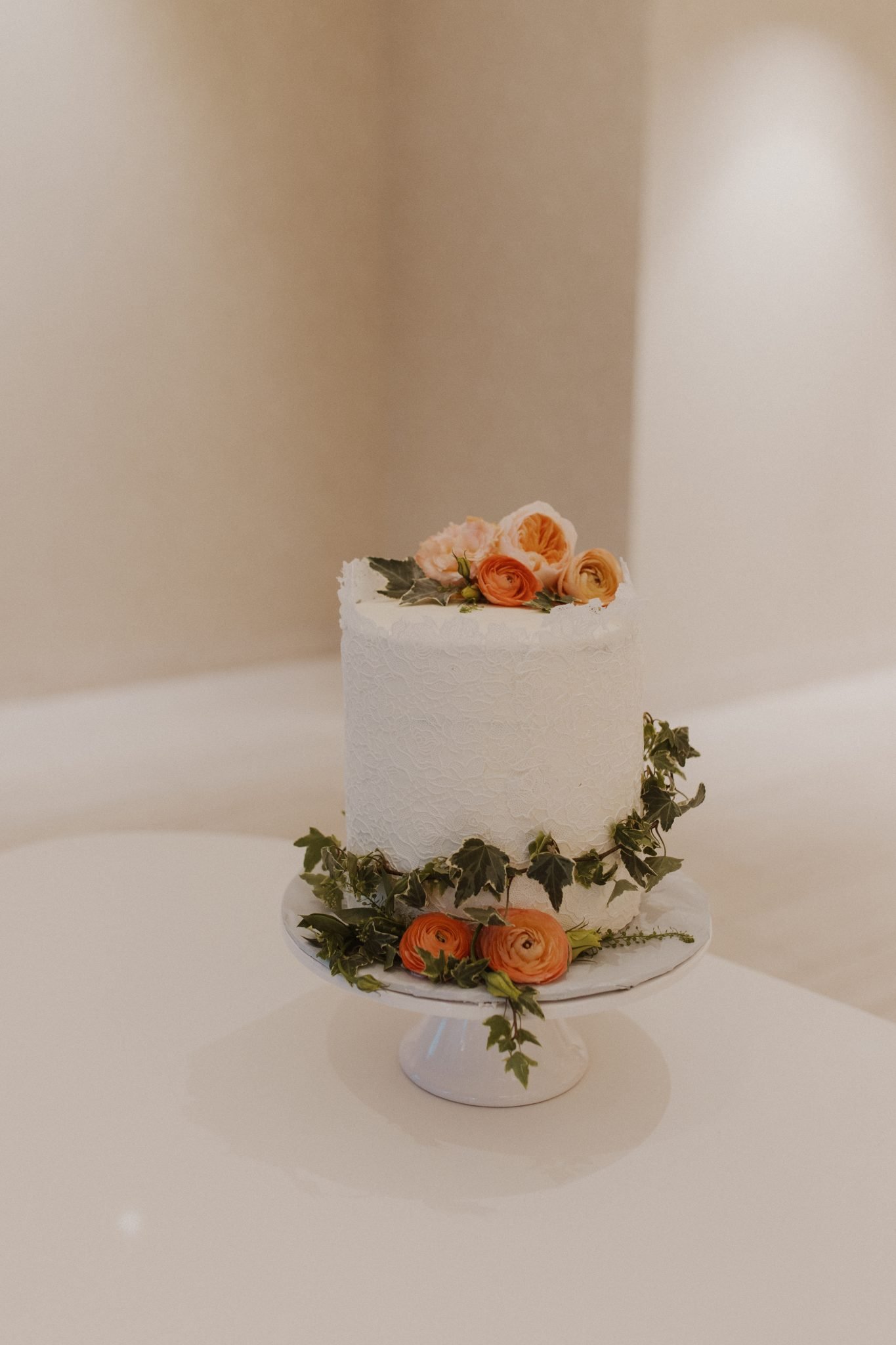 Classic white wedding cake topped with vibrant flowers at an Albuquerque celebration.
