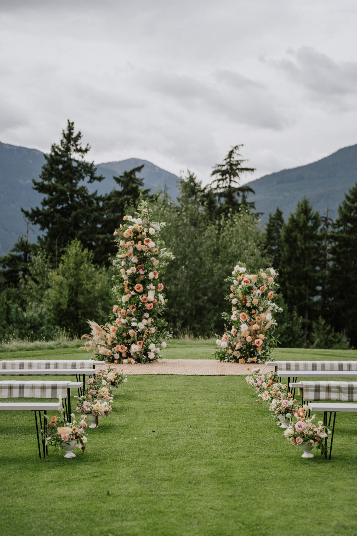 Wedding ceremony backdrop featuring floral archways against a mountain landscape at a Whistler summer wedding.