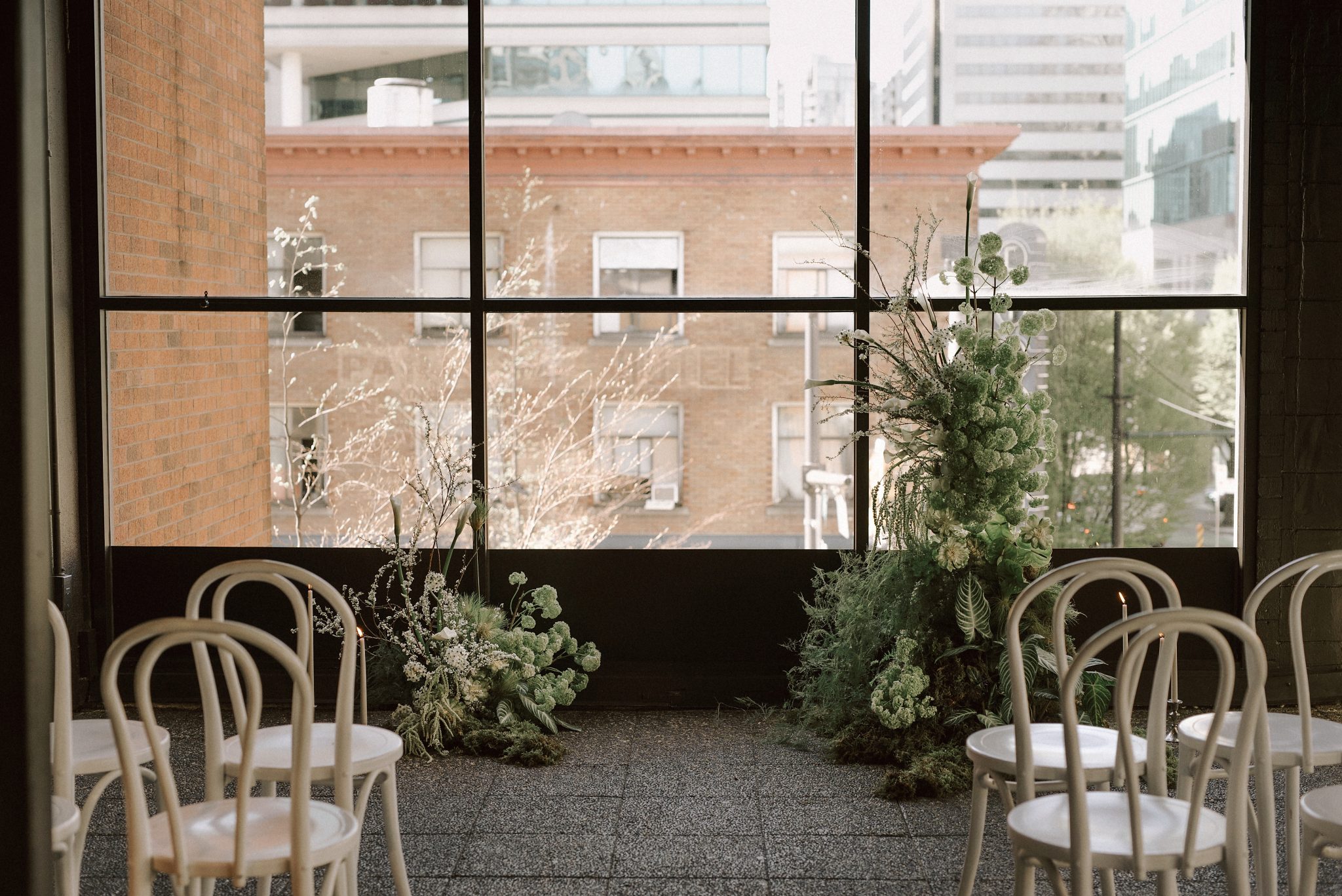 Modern indoor wedding setup with greenery arrangements at Slate Vancouver Wedding venue.