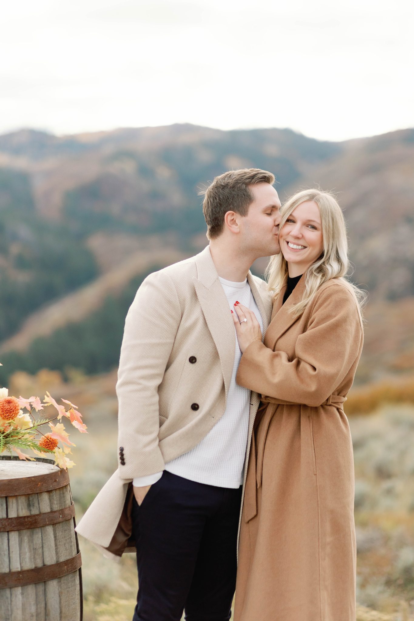 A couple sharing an intimate moment after a successful Park City proposal, framed by autumnal mountain scenery.