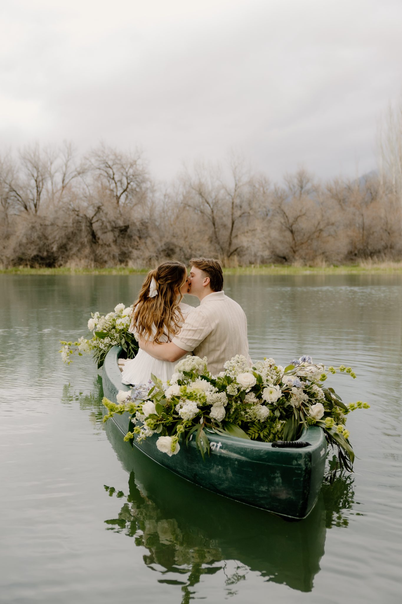 T Beebe Photo captures a tender kiss between the engaged couple in a flower-decorated canoe.