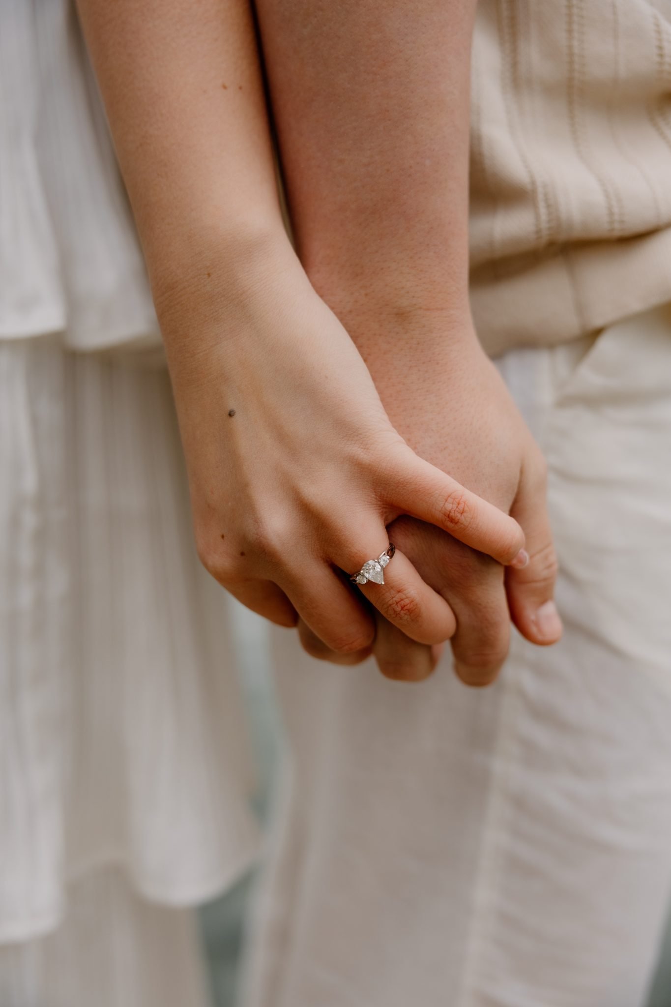 Close up photo of the soon to be bride's wedding ring holding hands with her partner captured by T Beebe Photo