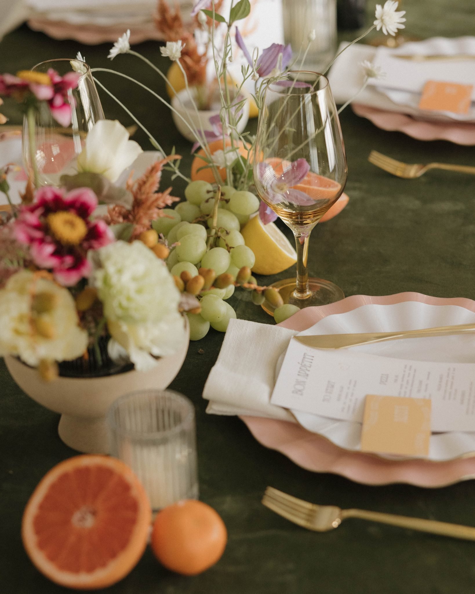 Close-up of a beautifully styled wedding table with flowers, fruits, and a detailed place setting at a summer wedding in Breckenridge.