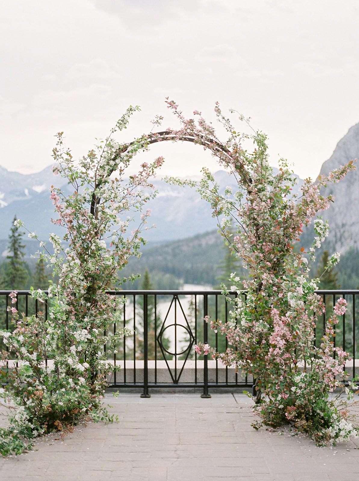 Floral arch with pink blossoms at a Romantic Pink Alberta Wedding Inspiration backdrop.