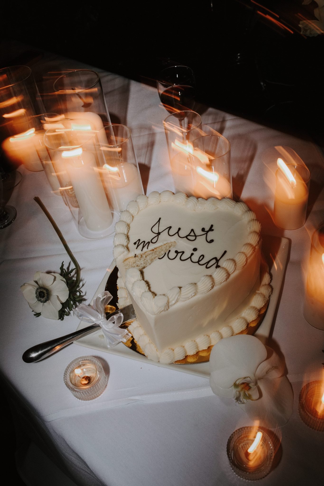 A heart-shaped "Just Married" cake surrounded by candlelight, creating a romantic atmosphere at a mountain wedding in Whistler.