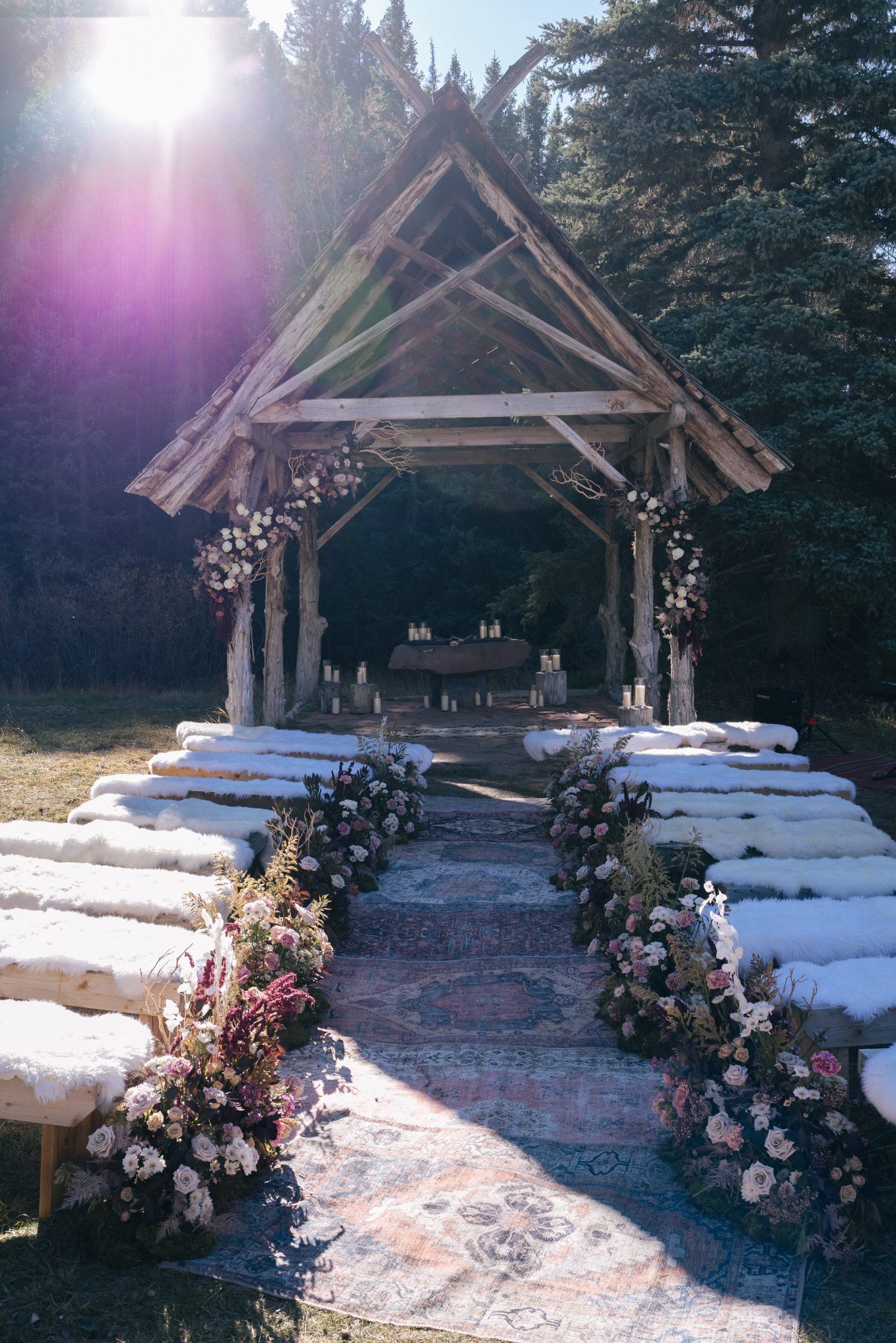 Scenic outdoor altar decorated with florals and rustic wood benches, ready for a Dunton Hot Springs Wedding ceremony.